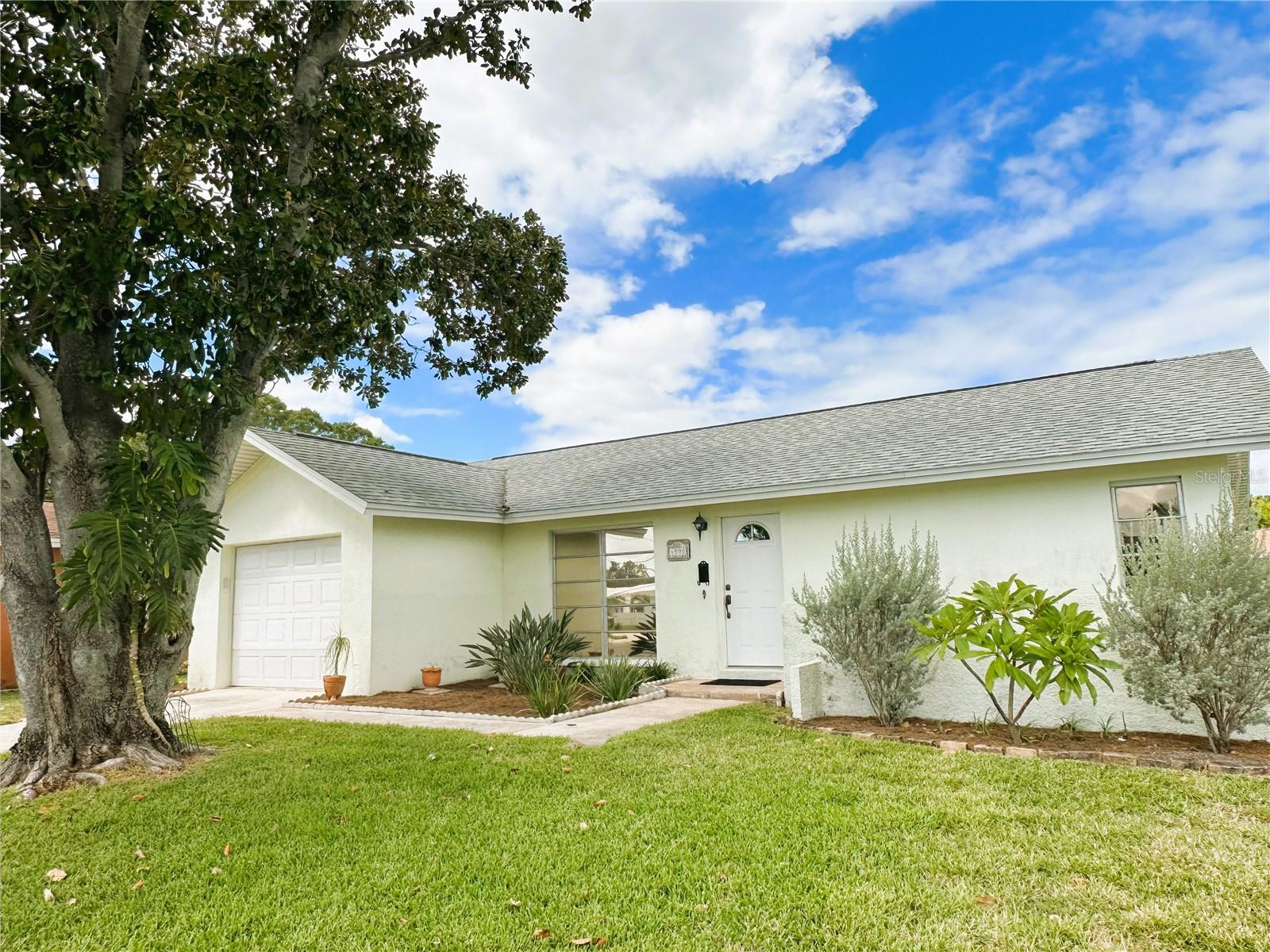 Discover The Lakes! A wonderful opportunity is available in this 55+ plus deed restricted community. Your low HOA fees include lawn maintenance, basic cable, internet, heated community pool, club house, shuffleboard courts, escrow reserves, and reclaimed water! Simple landscaping showcases one of the largest corner lots in this neighborhood at an incredible price. This well-maintained and truly loved home in a quiet cul-de-sac offers potential buyers a sanctuary that is ready and waiting for relaxation and peaceful living. This spotless and classic (2) bedroom, (2) bath (1) car garage home has great flow and is laid out just perfectly. The spacious living dining combination have lovely views to the front and to the rear of this bright, airy home. Softly carpeted and painted in soothing neutrals, the kitchen has a gleaming wood look kitchen floor, mullioned oak cabinets, and granite countertops. The meticulously clean one car garage comes complete with storage cabinets, shelving, pegboard for easy organizing, and conveys with a tastefully covered washer and dryer. The living room and the primary bedroom's sliding glass doors lead to your large screened lanai that is the perfect place to relax, sip, and watch the sky change colors as the birds chirp away. The primary bedroom also features a separate vanity area and spacious walk-in closet. This lovely home can be enjoyed just as it is or can become the perfect canvas for your fashionable upgrades. The kitchen has been modified to accommodate a central cable/ internet whole house hub. A/C installed in 2013 but runs perfectly.Refrigerator, dishwasher, and dryer all replaced in 2018. Solar protection film on the windows keeps the home cool and the electricity bill down and all of the tasteful window treatments convey with the home. The roof was replaced in 2018 and a brand new water heater was installed in 2023. Leasing is allowed and your pets are welcome! Clink on the link for a 3D virtual tour and take a wander through...this home won't last long at this price, so schedule your showing today!