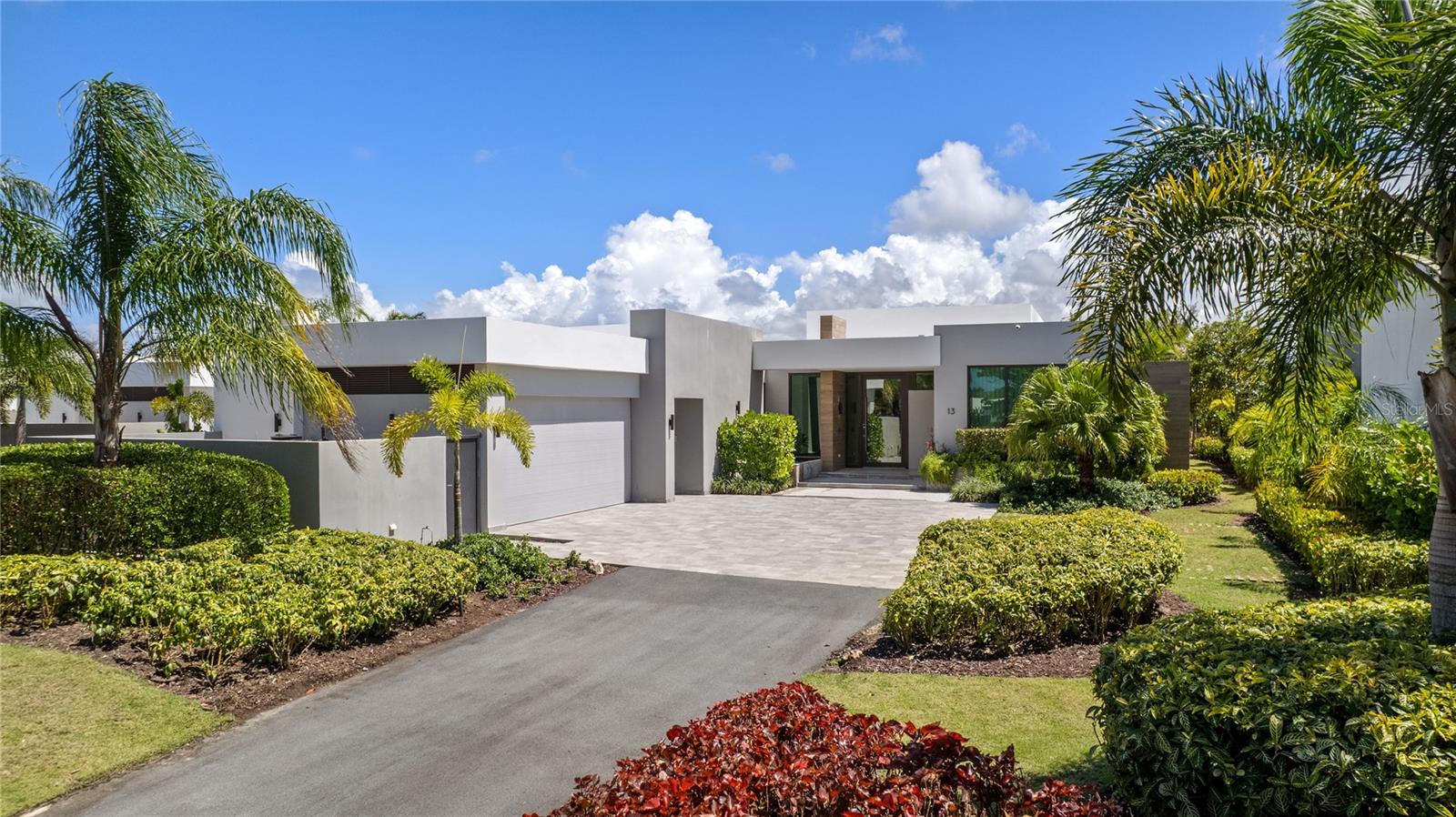 Set within The Isles at Dorado Beach Resort, this one-story residence presents an elegant expression of space, privacy, and indoor-outdoor living. Built in 2022, the home sits on a 1,451 SQMT lot, surrounded by water and golf course views that define the setting from the moment you arrive.

A double-height open layout anchors the main living area, where natural light, clean lines, and refined finishes create a sense of scale without losing warmth.

The living room, dining area, and kitchen connect in one continuous flow, opening fully to the terrace and outdoor lounge. Large sliding glass panels remove the barrier between interior and exterior, allowing the home to function as a single, extended living space.

The kitchen features a large culinary workstation and entertainment island, bespoke cabinetry, and integrated luxury appliances. It connects directly to the expansive outdoor BBQ terrace, creating an organic and natural transition for entertaining.

The residence includes four bedrooms, each with its own en-suite bathroom, plus a flexible additional room suitable for an office, media room, or guest space.

The primary suite is positioned to capture open views and direct access to the outdoor areas, complemented by a spacious bathroom and a layout focused on comfort and privacy.

Outside, a covered outdoor living and dining area leads to an inviting pool deck with an infinity-edge pool and jacuzzi, all oriented toward the lake and the Dorado Beach TPC Sugarcane golf course. The landscaping frames the property while maintaining open sightlines, reinforcing both privacy and connection to the surroundings.

Additional features include a powder room, pool bath, full air-conditioning system, water softener, cistern, and a community-wide generator. The residence is offered furnished, with interiors curated by Palacios to align with the home’s architectural language.

Located within The Isles, one of the most acclaimed communities inside Dorado Beach Resort, residents benefit from a gated environment with access to internal amenities including pools, tennis courts, gym, and recreational spaces. Resort membership further expands the lifestyle to include TPC championship golf courses, the Encanto Beach Club, the Watermill pool and amenities, a spa, fitness facilities, over five dining venues, the Rockefeller nature trail and an extraordinary community.

This residence combines scale, design, and location within a setting defined by water, landscape, and access to one of Puerto Rico’s most established resort communities in the Caribbean.