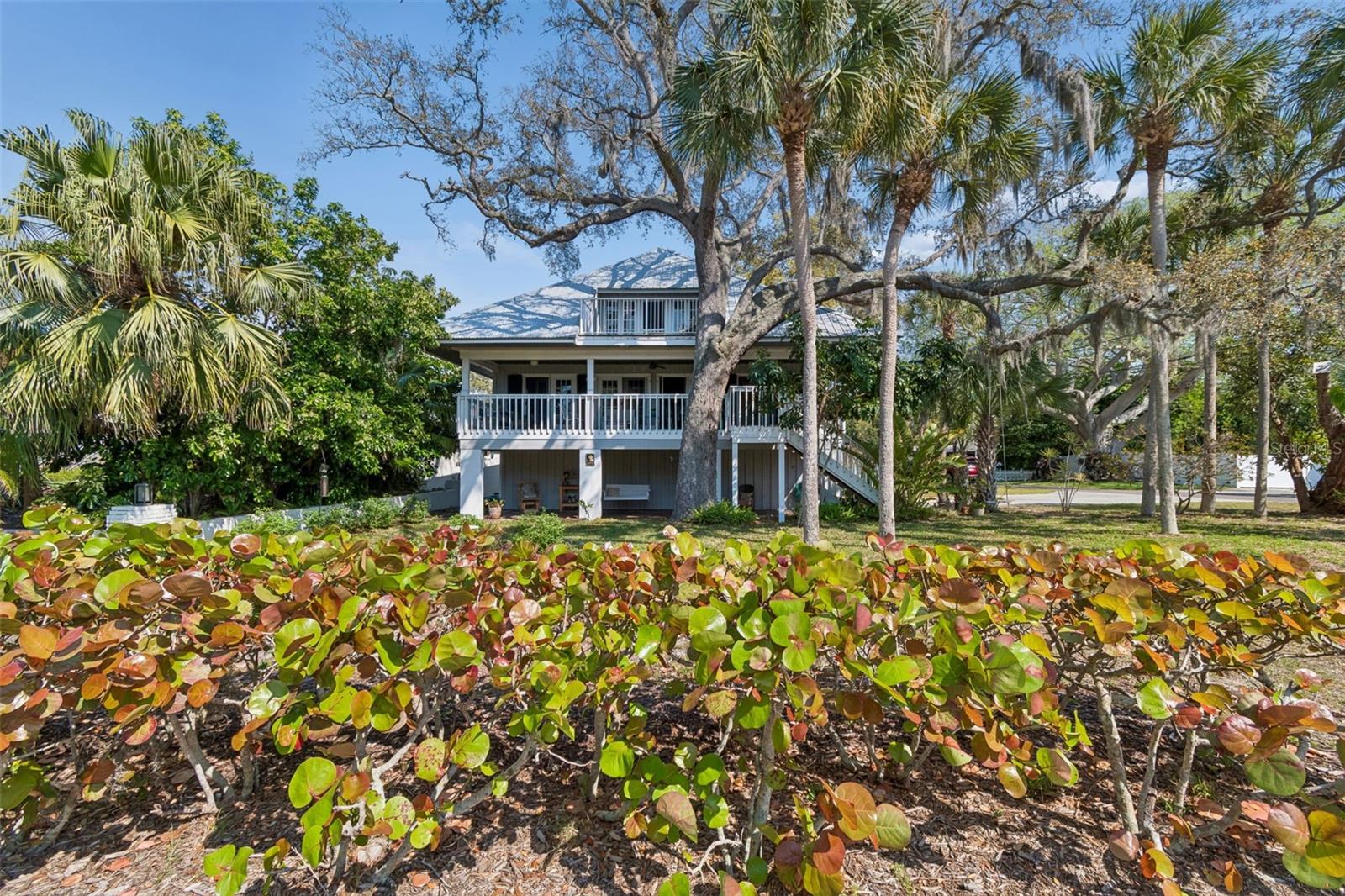 Coastal Key West style home with Gulf water views!  Located on a large corner lot in the heart of Crystal Beach. 30-year owners, this property NEVER FLOODED!! Treehouse-style setting that captures the essence of Old Florida living. This property features the great room layout with wood floors in the main living area.  Two brand new A/C units and a metal roof installed in 2011.A three way split floor plan .Primary suite is up the spiral staircase with a private sitting room &  3rd story  porch with Gulf water views!  Plenty of natural light shines in throughout the whole home! Seven sets of French doors and spacious porches off every room for your outdoor living enjoyment! A very peaceful and serene treehouse style setting with Gulf breezes. The sunrise & sunsets offer a spectacular pallet of pastel color skies in the morning and evening, along with birds chirping.  Wonderful cross ventilation on spring and fall days.  Full size laundry room off the back porch. The garage is spacious enough for 4 cars, workshop space and / or room to store your kayaks, paddle boards & golf cart. This is a non-deed restricted area with no HOA. Your watercrafts & recreational vehicles can be stored on site.  Located less than a block away from the Pinellas  Exercise Trail  offering  a 45 mile stretch. A few short blocks to Crystal Beach’s Live Oak Park, Gulf Shore park, Brand new fishing pier, and the coastline shell walking path on South Gulf Dr.  Less than 10 minutes to Downtown Dunedin to the south, or Tarpon Springs to the north. A prime Location! Come live the dream in the charming coastal community of  Crystal beach, established in the early 1900s. Still holding the old world character. A home you’ll be sure to be happy to own!