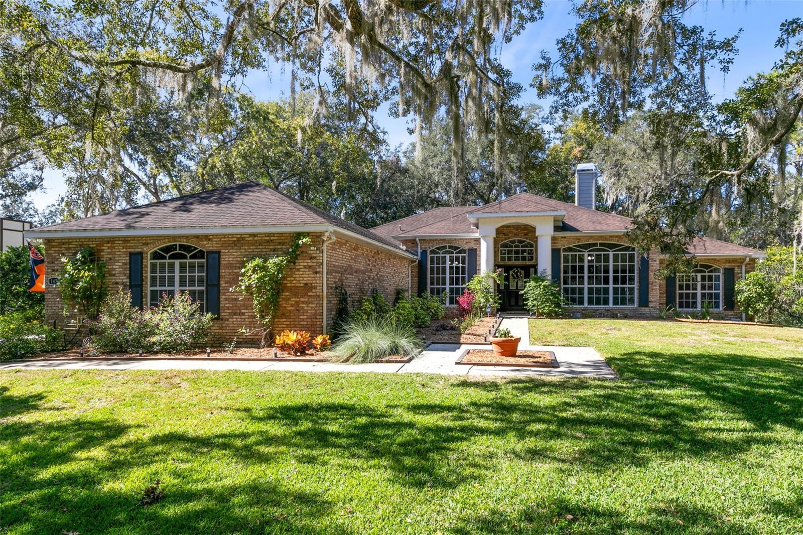 One or more photo(s) has been virtually staged. If your DREAM includes a stately BRICK home on nearly an acre of manicured lawn, nestled amidst Old Florida Oak Trees, with plenty of elbow room between neighbors, your first thought as you pull up to this immaculately maintained, MOVE-IN READY home in the desirable community of Westminster Wood will surely be "Welcome Home"! As you enter your new home, you will be taken by the STUNNINGLY REFINISHED HARDWOOD FLOORS, high ceilings, spacious feel, and abundance of NATURAL LIGHT that fills the formal dining space. To the right, Two BARN DOORS open to reveal a large FLEX SPACE - perfect for an office or game room! Do not miss the DOUBLE-SIDED FIREPLACE situated between the flex space and the SPACIOUS GREAT ROOM, giving the home a warm, cozy feel. The home's OPEN FLOOR PLAN and inviting ambiance make it perfect for hosting gatherings. The RENOVATED KITCHEN is a CHEF'S DREAM: featuring EXPANSIVE GRANITE COUNTERTOPS, 42" WHITE SHAKER CABINETS extending all the way to the eat-in kitchen where a built-in PANTRY provides ample storage for your culinary delights, a Range with Double Oven, and an exposed brick backsplash ties the space together. The Primary Suite boasts 2 walk-in closets, updated vanities and mirrors, a spa-inspired Soaking tub with built-in storage for towels and supplies, access to the Lanai through an additional HALF BATH, and best of all: it is tucked far away from the other 2 bedrooms and has a separate office nearby in this split-bedroom plan. There is no shortage of loos- with 2 Full baths and 2 Half Baths featuring NEW VANITIES and NEW TOILETS (2022), available for guest use. As fabulous as the inside is for entertaining: The backyard is an OUTDOOR OASIS! MATURE TREES and prim landscaping make you feel that you are in a secluded garden. The newly installed pavers highlight the brick walkway leading to the FIRE PIT and the TWO GAZEBOS. Dreaming of a hot tub or an outdoor kitchen? One of the gazebos is already pre-wired and ready for your vision! The generously sized THREE-CAR GARAGE allows room for multiple vehicles as well as additional storage. You can rest easy knowing that this home features a NEW A/C (2022), was RE-PLUMBED IN 2022, and has a water heater installed in 2019. Whether your commute includes the Theme Parks, Downtown Orlando, or the Beaches that make Central Florida famous - the proximity to I-4, Hwy 44, HIGHLY RATED Stetson University, and Historic Downtown Deland make this a home you don’t want to miss!