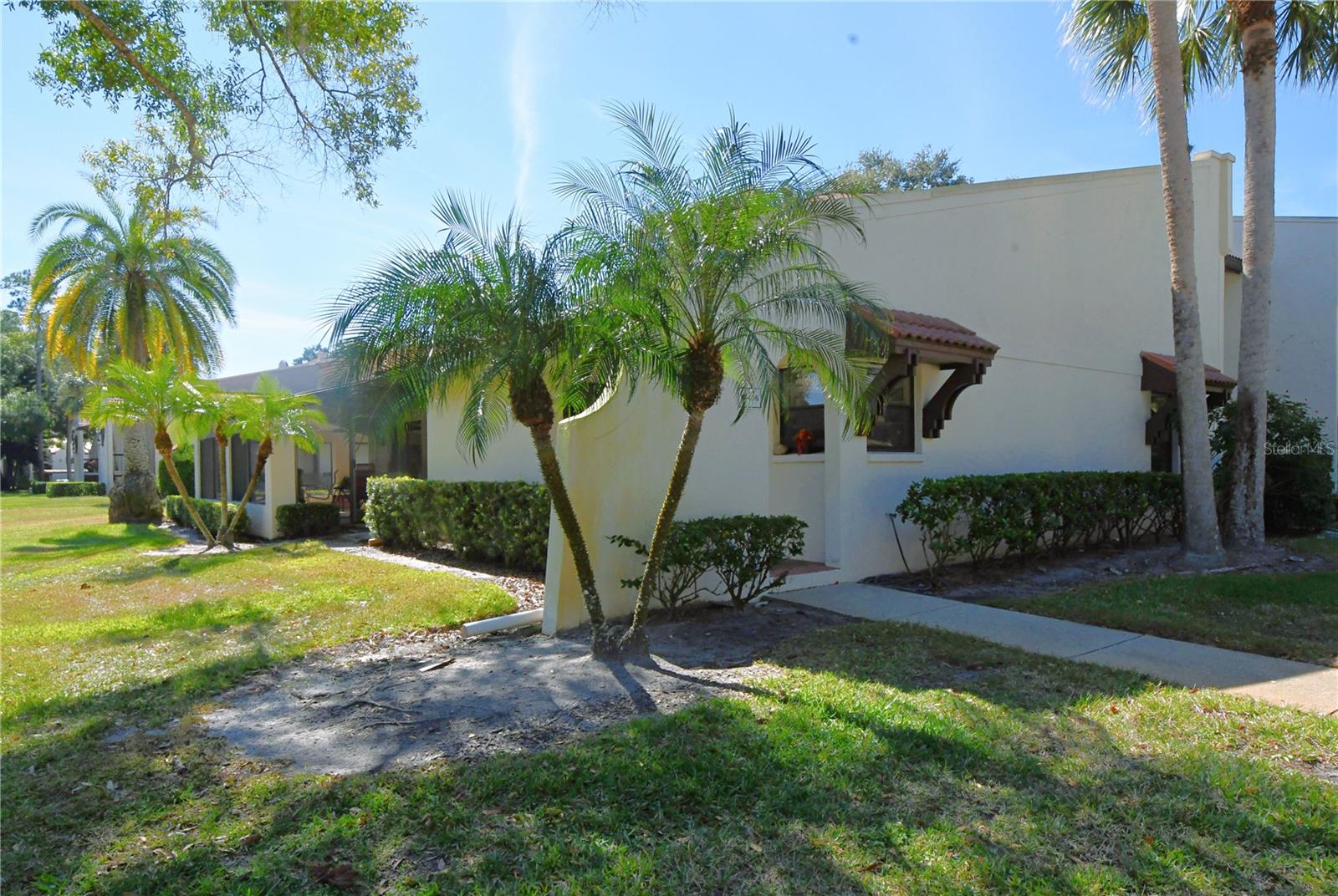 Welcome to this meticulously maintained, move-in-ready 2 bedroom, 2 bathroom condo nestled in sought-after Tarpon Woods along the  Eastlake corridor. As you step through the elegant arch and into the covered entryway, you're greeted by a warm foyer boasting a generous storage closet.

The heart of this home is undoubtedly the grand living and dining space, bathed in natural light, accentuated by lofty 12-foot vaulted ceilings equipped with a sleek ceiling fan. A seamless transition through sliding glass doors reveals a sprawling wrap-around screened-in porch, a serene escape for relaxation or entertainment.

Culinary endeavors await in the eat-in kitchen, a perfect blend of functionality and style. It features a breakfast bar, expansive countertops for meal prep, a double porcelain sink set below a charming corner window, and a suite of milk-toned appliances, including a range, microwave, Whirlpool dishwasher, and refrigerator. Snow-hued cabinets and ceramic tile flooring enhance the crisp, clean aesthetic, providing abundant storage for all your kitchen needs.

Convenience is key with a stackable in-unit GE washer and dryer, simplifying your daily routine. The second bedroom is a spacious sanctuary, offering a neutral color palette, a built-in closet, and plush Berber carpeting, creating a tranquil space for rest.

The adjacent second bathroom doesn't skimp on style or function, featuring ceramic tile flooring, a tub with shower, a mirrored vanity with ample storage, and tasteful overhead lighting.

Retreat to the luxurious primary bedroom, a generously sized haven with an ensuite bath, a massive walk-in closet, and an additional built-in closet. Like-new Berber carpeting, a ceiling fan, and sliding glass doors to the covered, screened-in porch create an atmosphere of private indulgence.
The ensuite primary bath features convenience and functionality with ceramic tile flooring, a mirrored vanity with dual sinks, plentiful storage, overhead lighting, and a walk-in shower designed for a spa-like experience.

The pièce de résistance is the L-shaped screened-in patio, measuring 20 feet by 8 feet and extending to 25 feet by 8 feet. It boasts tile flooring, a vaulted ceiling, and a ceiling fan, all set up for year-round enjoyment, making this condo a true embodiment of Florida living at its finest.

This residence features dedicated covered parking, with additional parking available for guests. The condominium association fees facilitate a maintenance-free living experience, encompassing the care of exterior structures, landscaping, community pool maintenance, and taxes for shared spaces. Nestled amidst golf courses, serene parks, the expansive Lake Tarpon, scenic biking paths, the distinctive Tarpon Springs Sponge Docks, various shopping destinations, and healthcare services, this property isn't merely a home; it's a gateway to a lifestyle of comfort, convenience, and recreation. Discover the allure, comfort, and vast potential of this exceptional home in Tarpon Woods.

This condo is a rare gem in Tarpon Woods, offering comfort, style, and convenience in one of the most desirable locations. Don't miss the opportunity to make this your new home!