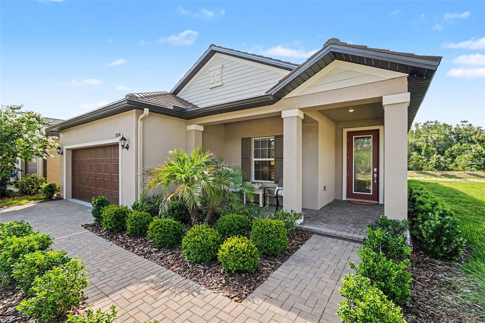 Enjoy peaceful pond views and move-in-ready living in this beautifully upgraded 2-bedroom, 2-bath home with a versatile flex room in Medley at Angeline, one of Pasco County's most vibrant 55+ active adult communities. Situated on a premium homesite with a true year-round pond view, this home offers the privacy and tranquility that are hard to find, along with extra space between neighboring homes, a charming front porch elevation, and a decorative glass front door that fills the home with natural light.

Inside, you'll find tile flooring throughout with no carpeting, professionally painted walls in Sherwin-Williams Shoji White, elegant crown molding, custom window treatments, and thoughtful upgrades throughout. The well-appointed kitchen features quartz countertops, shaker-style cabinetry, stainless steel appliances, an upgraded kitchen sink, and a large center island with seating—ideal for entertaining and everyday living.

The spacious primary suite offers a walk-in closet and an ensuite bath with dual vanities and a glass walk-in shower. A comfortable guest bedroom and full bath provide privacy for visitors, while the flex room is perfect for a home office, hobby room, or additional living space. The laundry room includes added cabinets for extra storage, and the extended-depth two-car garage provides room for a golf cart, workshop area, or additional storage.

Located in an established section of the community near the clubhouse and mailboxes, this home allows you to enjoy all that Medley at Angeline has to offer without the disruption of ongoing construction. Residents enjoy resort-style amenities including a clubhouse, resort-style pool, fitness center, pickleball courts, scenic walking trails, and a full calendar of social activities.

Why wait for new construction when you can enjoy premium upgrades, a spectacular pond view, enhanced privacy, and immediate occupancy in one of Angeline's most sought-after active adult communities?