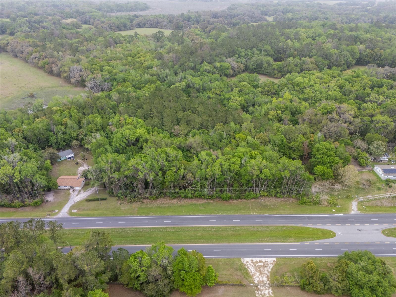 Discover the potential of this rare 16-acre property located at Micanopy with direct frontage and easy access right off US Highway 441. Tucked behind a gated entrance and surrounded by mature trees, this private and peaceful property offers the perfect blend of seclusion, convenience, and opportunity in one of North Central Florida’s most desirable rural settings. Whether you are searching for a private homestead, investment opportunity, mini farm, recreational retreat, or future homesite with acreage, this versatile property delivers endless possibilities. Enjoy wide open space, natural surroundings, and the tranquility of country living while still being just minutes from I-75 for an easy commute to both Gainesville and Ocala. The property currently features a two-bedroom, one-bath single-family home with an existing well already on site. The home is in need of a full rehab, creating an excellent opportunity for investors, builders, or buyers looking to renovate or start fresh and build their dream property. With 16 private acres, there is ample room for horses, livestock, equipment storage, gardening, recreational vehicles, additional structures, or expansion opportunities. Buyers searching for acreage in Florida will appreciate the combination of privacy, gated access, mature trees, functional land, and convenient highway access. This property is ideal for those seeking rural living with close proximity to shopping, dining, hospitals, universities, and all the amenities of Gainesville and Ocala. If you have been looking for private acreage with flexibility, natural beauty, and incredible potential, this unique Micanopy property is a must-see opportunity.