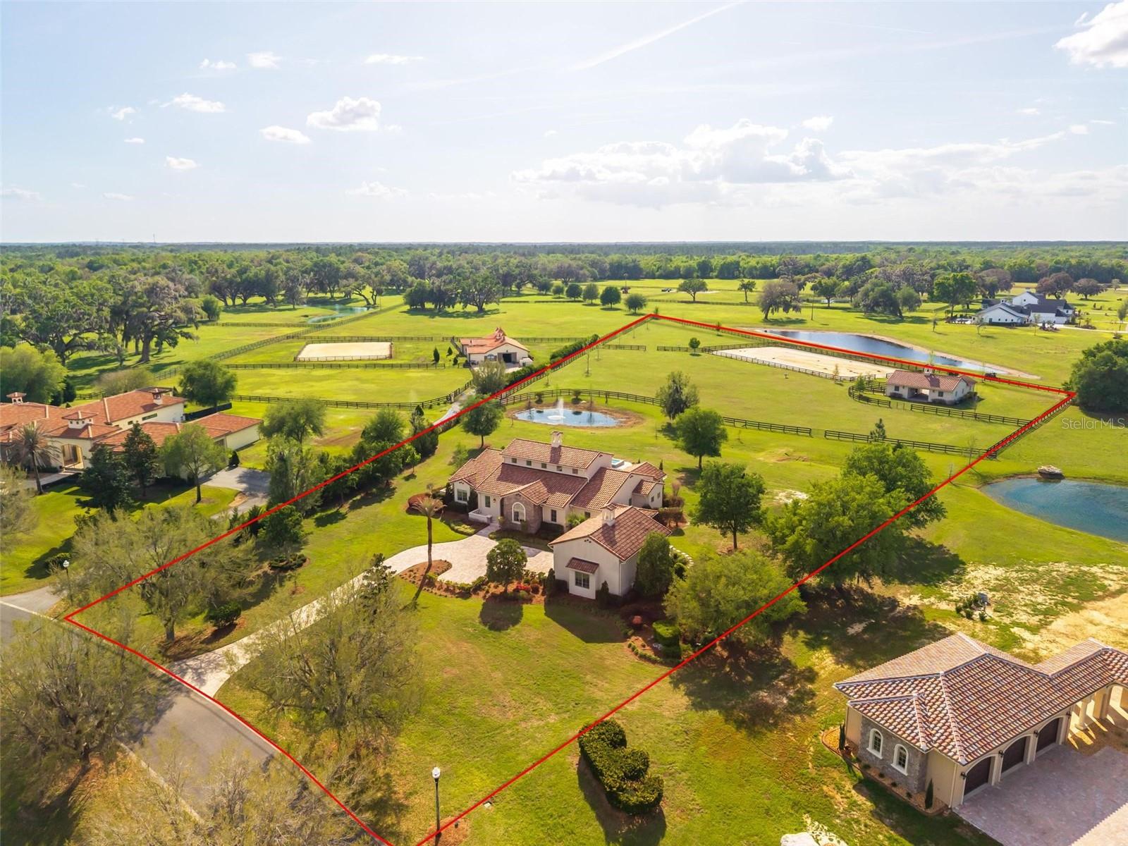 Discover your dream equestrian retreat with this stunning 5.34-acre Tuscan-style estate, located within a beautifully maintained and secure gated community featuring miles of scenic riding trails. Surrounded by an expansive 8,000-acre State Forest, this property offers unmatched privacy and natural beauty—yet remains just 20 minutes from the World Equestrian Center and only 5 minutes from shopping, dining, and medical facilities. Ideally positioned between the Rainbow River and Ocala, it delivers both convenience and tranquility.

The luxurious residence boasts over 3,800 square feet under air, offering 4 bedrooms, 4 bathrooms, plus a versatile fifth room on the second floor. Designed with both elegance and functionality in mind, the home features a dramatic living area with cathedral ceilings, a gas fireplace, and an open custom kitchen complete with high-end finishes, a wine cabinet, and a spacious pantry. A formal dining room, abundant closet space, tray ceilings throughout, travertine flooring inside and out, plaster walls, and precast trim details elevate the home’s refined character. The expansive primary suite provides a private retreat, while the split floor plan ensures comfort and privacy for all.

A breezeway leads to a generous two-car garage with an additional air-conditioned upstairs room—ideal for guests, an office, or hobby space. This award-winning model, recognized by the Builders Association in 2016, blends timeless architecture with modern living.

Outdoor living is equally impressive, featuring a heated 41’ x 14’ pool and spa added in 2020, perfectly positioned to capture breathtaking sunset views. Equestrian amenities include a beautifully constructed 3-stall concrete barn (14x14 stalls) with a tack room, full bathroom, and attached garage (built in 2022), along with two paddocks equipped with automatic waterers, a 200 x 100 arena, and durable creosote board fencing. Ride directly from your backyard onto miles of private trails.

Thoughtfully landscaped with mature and newly planted trees for added shade and privacy, this turnkey property is offered newly furnished, making it truly move-in ready. A rare opportunity to own a luxury equestrian estate where lifestyle, location, and design come together seamlessly.