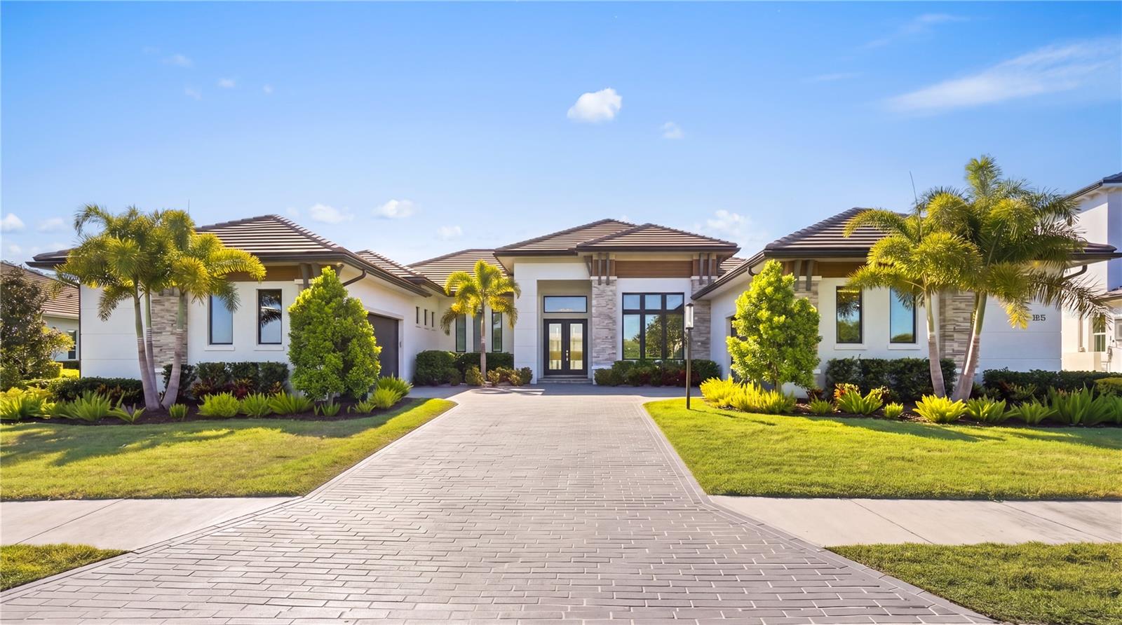 Under contract-accepting backup offers. Custom built in 2024, this luxury John Cannon Homes Tindarra model estate is designed for refined Florida waterfront living. Richly detailed yet timeless, the residence captures breathtaking western sunset views along a serene canal with direct access to the Manatee River, offering luxury waterfront real estate, boating lifestyle, and the ultimate Florida living experience.
Located in The Islands on the Manatee River, an award-winning, gated waterfront community recognized as Best Overall Community (Cat 3) in the 2026 Parade of Homes for an eighth year, this exceptional residence spans 3,612 square feet under air (5,291 total). The thoughtfully designed split floor plan features three spacious en-suite bedrooms plus a full pool bath, creating an ideal balance of privacy and elevated entertaining.
Upon entry, the home makes a striking impression with custom inlay wood flooring, designer wall moldings, curated lighting, and a dramatic 14-foot ceiling. The great room showcases a soaring 11-foot recessed step ceiling with LED accent lighting, a sleek 72-inch electric fireplace, and expansive canal views. The space flows seamlessly into the dining area with illuminated custom built-ins and continues into a chef’s kitchen of exceptional caliber. Designed for the most discerning culinary enthusiast, it features solid wood, soft-close cabinetry, a dramatic Quartz waterfall island with walnut seating detail, and premium smart Dacor appliances including a six-burner gas range with convection and steam capabilities, flush-mount ceiling vent, wall oven with convection, warming drawer, microwave with convection and speed broil, and a built-in refrigerator and freezer. A discreet hideaway pantry enhances both function and elegance.
An expansive bonus room extends the main living space—ideal as a media room, club room, or sunset lounge—framed by picturesque water views and enhanced by a recessed step LED-lit ceiling. A private study with sliding glass doors opens to the lanai, offering a flexible home office or serene retreat. The owner’s suite is a true sanctuary, featuring private lanai access, a recessed step ceiling, and dual custom walk-in closets, including a boutique-style dressing space with chandelier. The spa-inspired bath offers a dramatic walk-through double-entry shower, soaking tub, and full wall dual vanities, blending indulgence with everyday comfort.
Car collectors and hobbyists will appreciate the dual two-car garages, providing four-car capacity, complemented by a 14-foot paver driveway and additional overhead storage. Outdoors, the residence transforms into a private resort-style retreat with an expansive 1,008-square-foot lanai, fully equipped outdoor kitchen with Edgestar gas grill, panoramic screen enclosure and 20/20 mesh screen, and multiple lounging areas designed for effortless entertaining. Trex decking leads to a private, lighted 260-square-foot dock with a 15,000-pound boat lift, power, and water, offering seamless access to the boating lifestyle.
Additional features include PGT impact windows and doors, smart home wiring (Cat6), integrated audio, security system, custom lighting, crown molding, low-voltage window coverings, a private irrigation well, a 500-gallon buried propane tank, and a whole-house Generac generator—all delivering both modern convenience and peace of mind.
A rare opportunity to own a like-new waterfront estate, this residence embodies the perfect blend of luxury, craftsmanship, and lifestyle.