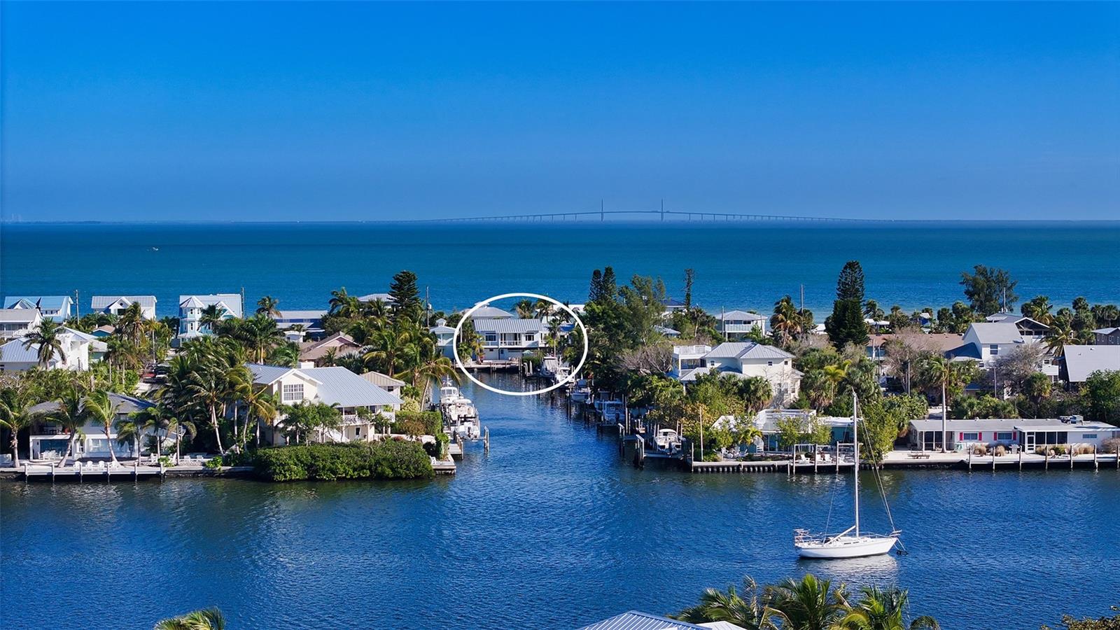 Nestled on the enchanting Anna Maria Island, this exquisitely reimagined coastal property is a harmonious blend of luxury and tranquility, providing an unparalleled lifestyle for those seeking the perfect Gulf Coast paradise. Boasting a prime location, this investment-minded gem is zoned for short-term rental, with an added rare conforming two-bedroom, one-bath apartment on the first floor—a valuable addition for dual residency, annual or short-term rental, or as a primary/guest residence combination.

As you step into the primary residence, a breathtaking panorama of glistening canal views awaits, stretching all the way to Bimini Bay. The open and airy floor plan seamlessly integrates indoor and outdoor living spaces, creating a haven of relaxation. Large impact-rated windows and French glass doors bathe the interior in natural light, accentuating the carefully curated coastal decor.

Outdoor spaces are a splendor, with verandas off the living room, primary suite, and kitchen providing the perfect setting for al fresco dining, sunset libations, or simply lounging with a good book while savoring the salty breeze. The heart of the residence is a spacious living area connected to a gourmet kitchen featuring beautifully customized cabinetry and waterfall granite countertops. High-end appliances, including a Wolf gas cooktop, Subzero refrigerator, Miele steam oven, Bosch dishwasher, and Kitchen Aid wall oven, cater to the most discerning culinary enthusiasts.

The expansive primary suite is a private sanctuary with French doors opening to the veranda, a wine and coffee wet bar, custom cabinetry, private office, two walk-in closets, separate HVAC zone, and an adjacent laundry room. The ensuite bathroom boasts clean lines, elegant fixtures, and a luxurious bathing alcove surrounded by bay windows.

Beyond the captivating interiors, this coastal gem invites unlimited outdoor enjoyment. With frontage on a 90-foot-wide canal, dock your boat just steps away from your back door for easy access to Tampa Bay, the Intracoastal Waterway, and the Gulf of Mexico. The southern exposure at the rear of the property ensures endless hours of sunshine, perfect for lounging around the expansive saltwater, heated pool. Launch a SUP or kayak on Tampa Bay from the public access directly across the street or enjoy morning coffee in the enchanting garden retreat.

Close to Anna Maria Island attractions, from Pine Avenue’s charming boutiques and delectable restaurants to City Pier and Park, residents can explore the vibrant local culture and stunning beaches at Bean Point without venturing far from home. Whether it's morning coffee in the garden, dinner al fresco on the terrace, a refreshing swim in the saltwater pool, or a leisurely day boating, this coastal paradise offers a lifestyle where the beauty of the outdoors seamlessly merges with the elegance of the interior spaces. Are you ready for your next chapter in paradise? Bedroom Closet Type: Walk-in Closet (Primary Bedroom).