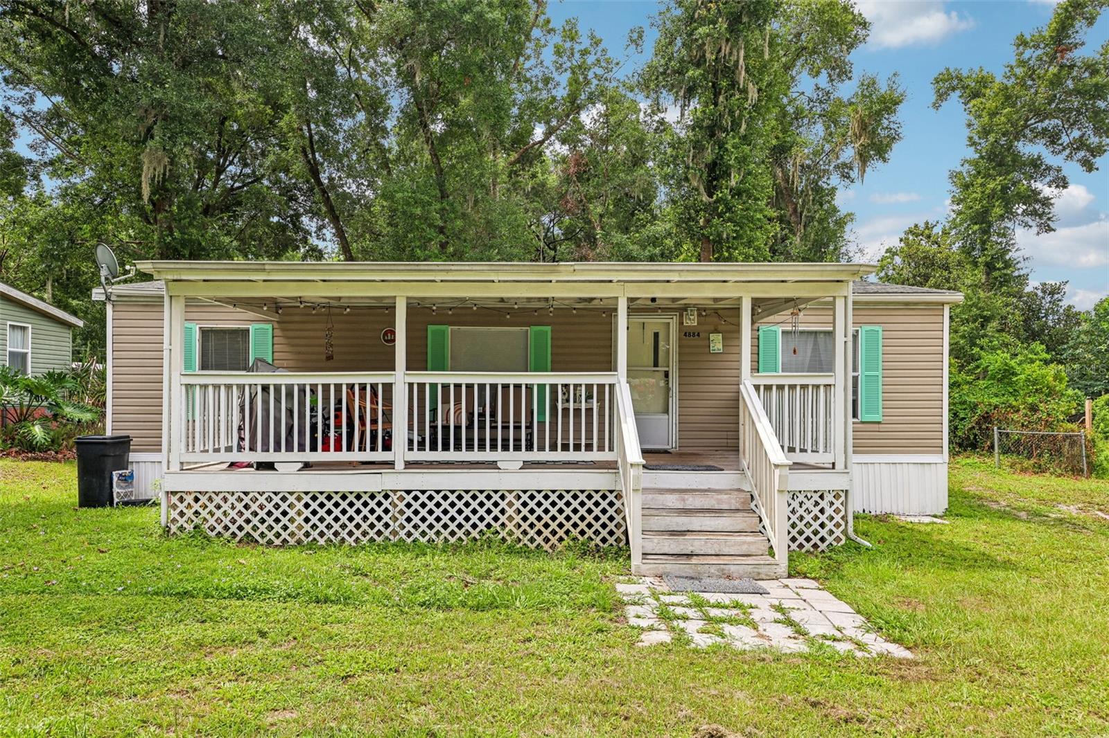 Adorable 3-Bedroom, 2-Bath Manufactured Home! This home features an open floor plan with luxury vinyl plank flooring throughout the living room, dining area, and kitchen. Recent updates include a roof replaced in 2016, HVAC system in 2023, and an updated water heater. Fresh interior paint gives the home a bright, move-in-ready feel. Relax and enjoy the outdoors from the large covered front porch, offering plenty of space for rocking chairs, morning coffee, or evening gatherings. The shaded yard provides additional outdoor enjoyment and privacy. FHA financing eligible and conveniently located near The Villages, Ocala, and I-75, making shopping, dining, and commuting a breeze. Don't miss this great opportunity!