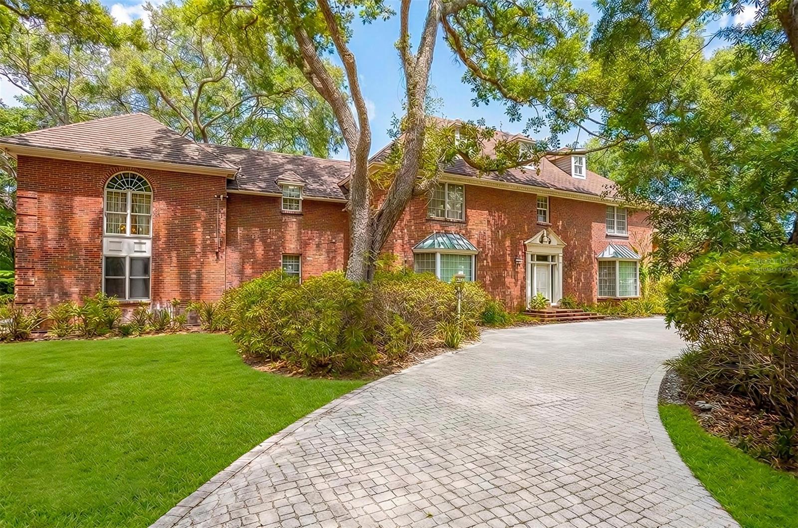 One or more photo(s) has been virtually staged. This home tells a story the moment you step inside. Music still seems to linger in the air, and every room carries its own chapter. Creativity flows as easily as the ocean breeze just minutes away. You enter through the foyer into a massive open living space with soaring vaulted ceilings, anchored by a stunning brick fireplace that fills the room with warm, timeless character. This space has hosted legendary recording sessions, and you can feel that musical history the second you walk in. Solid wood cabinetry and exquisite custom woodwork grace every corner of the home. The inside opens seamlessly to the outdoor entertaining area through wide, graceful transitions designed for effortless living and gatherings. Just off this grand room sits a cozy library with its own high-end sound system, perfect for quiet evenings with a book or your favorite vinyl. At the other end, a majestic office with soaring ceilings and beautiful stained glass windows offers an inspiring place to create or focus. The kitchen is a true chef’s dream, featuring a large island with an eat-in bar, a professional Viking oven and stove, Sub-Zero refrigerator and freezer, dedicated dining space, and plenty of room to gather, all overlooking the ravishing pool and expansive backyard beyond. Upstairs, the spacious primary suite feels like a private sanctuary, complete with customized his-and-hers closets, a dramatic spiral staircase descending to the majestic office below, a large walk-in steam shower, separate tub, dual sinks, another fireplace, and a gorgeous balcony overlooking the backyard sanctuary. A thoughtfully designed floor plan provides exceptional privacy throughout. You’ll also find an exercise room with an infrared sauna, laundry, kitchenette, additional bedrooms, and bathrooms on the same level. The third level offers a large, versatile room with its own bathroom and fireplace, ideal as a playroom, private workspace, or rehearsal space. Out back, a sparkling saltwater pool and spa await, surrounded by nearly two flat acres of peaceful private land. There’s an equipment shed, additional storage, a two-bedroom guest house ready for your personal touch, and an oversized three-car garage with plenty of parking. With gorgeous wood floors, unique design, and a perfect blend of seclusion and convenience near shopping, dining, the airport, and beaches, this property sits in a non-flood zone within an unincorporated part of the county. It offers far more than a house—it delivers a true lifestyle. Want to see it in person?