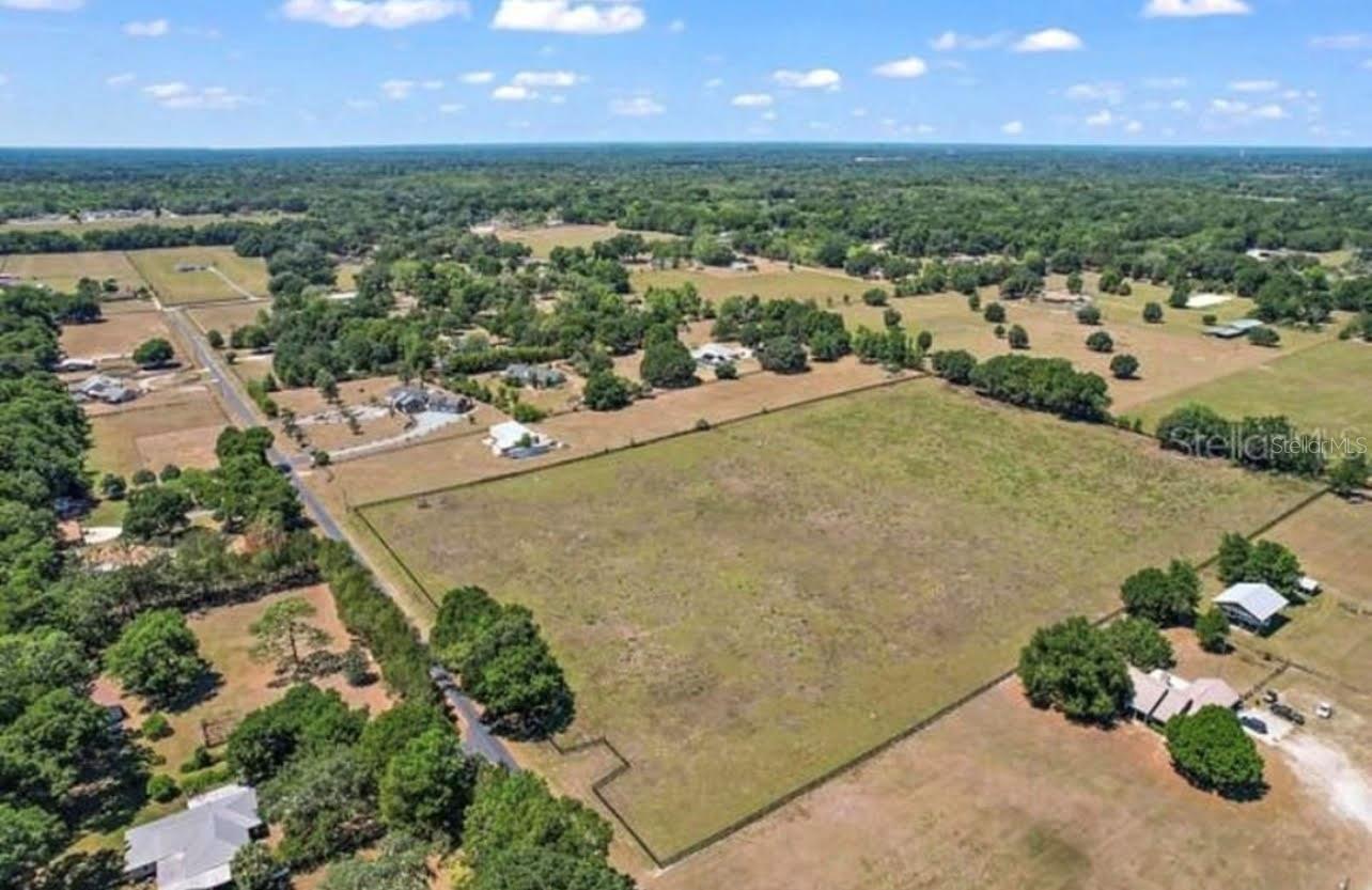 ** $50,000.00 PRICE REDUCTION = BIG OPPORTUNITY **  Exceptional opportunity to own 11.95 acres (more or less) of high and dry A-1 zoned land in a PEACEFUL RURAL setting just minutes from The Villages with convenient access to I-75. This beautiful parcel is fully enclosed with a gated entrance and 4-board fencing, making it ideal for horses, livestock, or those seeking space for a PRIVATE COUNTRY ESTATE. Power pole and a deep well installed in 2017 for livestock (approximately 120 feet deep) is already in place, adding immediate functionality for agricultural or equestrian use. Located outside of a flood zone, the property offers both peace of mind and usability. A berm currently used for shooting is located at the rear of the property and could also provide useful fill material for a future homesite. Access is provided by a private paved lane serving the neighboring properties, offering a quiet setting with one way in and one way out, minimizing through traffic and enhancing privacy. !! NO HOA !! Whether you are looking to build a custom dream home, create an equestrian property, establish a small farm, or invest in acreage, this property offers ENDLESS POSSIBILITIES in a highly DESIRABLE location.