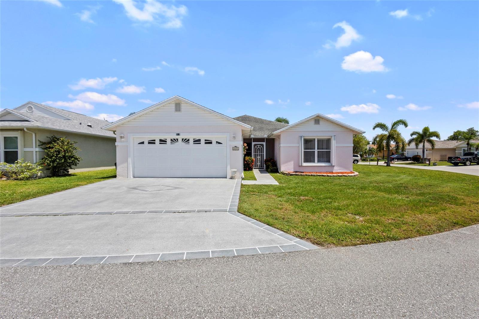 Reduced for Quick Sale!! Welcome to the wonderful community of Spanish Lakes! This lovely, move-in ready home offers the perfect blend of comfort and Florida charm. Inside, you'll find three bedrooms and 2 bathrooms, along with a convenient two-car garage. The highlight is an amazing Florida room, ideal for relaxing and entertaining guests. This home also features practical updates, including a new AC unit installed in 2024 and a newer hot water heater. It's also available partially furnished for an easy transition. For added peace of mind, accordion storm shutters are installed throughout. This property is on a land lease within an active community, offering resort-like amenities in a beautiful and quiet setting. The monthly lot rent is an attractive $595.86. Spanish Lakes boasts a fantastic location, close to a variety of shopping options and excellent restaurants, allowing you to truly enjoy the Florida lifestyle. Come and experience the best of Florida living today!