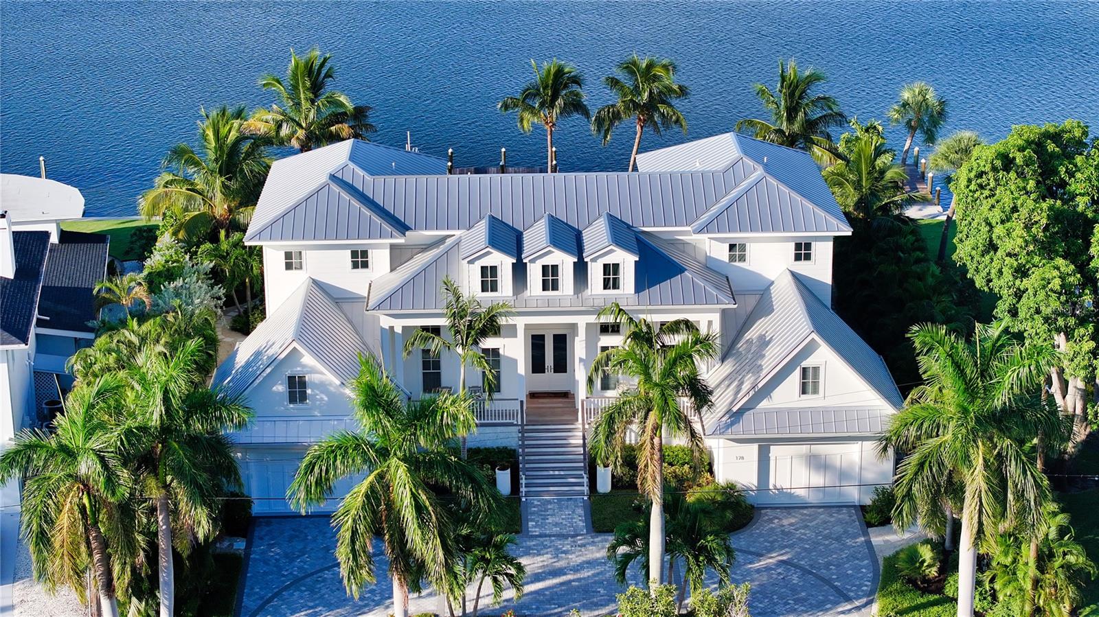 Rarely available! This coastal contemporary masterpiece sits on 18,000 square feet of prime bayfront on St. Armands Key. Unobstructed views of Sarasota Bay create a stunning backdrop from every angle, enhancing the beauty of this custom-built home, completed in 2021. Offering 5,064 square feet of elegant living space, the residence features four bedrooms, four and a half baths, and two bonus rooms easily adaptable as extra bedrooms. Expansive decks and lush outdoor areas capture the essence of Florida living. Inside, an airy, open floor plan connects a light-filled living room, cozy sitting area with an electric fireplace, and a chef’s kitchen equipped with high-end appliances. The serene master retreat, with an expansive terrace, offers dramatic views of the pool and bay, where each sunrise unfolds like a masterpiece, inviting tranquility and inspiration. Two additional guest suites, each with private terraces, and a third suite with a built-in Murphy bed, provide ample comfort and privacy.

Outside, a two-tiered stone deck, saltwater pool, firepit, and verdant landscaping are perfect for entertaining or tranquil al fresco dining. Boaters will appreciate the dock accommodating a 15,000-pound vessel, with a lower launch for kayaks and canoes. Practical conveniences include a whole-house water filtration system, three HVAC zones, a generator, elevator, security systems, and two one and a half garages with electric car chargers and epoxy-coated floors.

When you're ready to venture beyond your private paradise, the chic boutiques and acclaimed restaurants of St. Armands Circle are just two blocks away. The sands of Lido Beach are just beyond, and the vibrant energy of downtown Sarasota is only a quick drive over the John Ringling Causeway. Enjoy the best life in this spectacular waterfront retreat in the heart of a community of culture and natural beauty.

All offers must be accompanied by Proof of Funds.