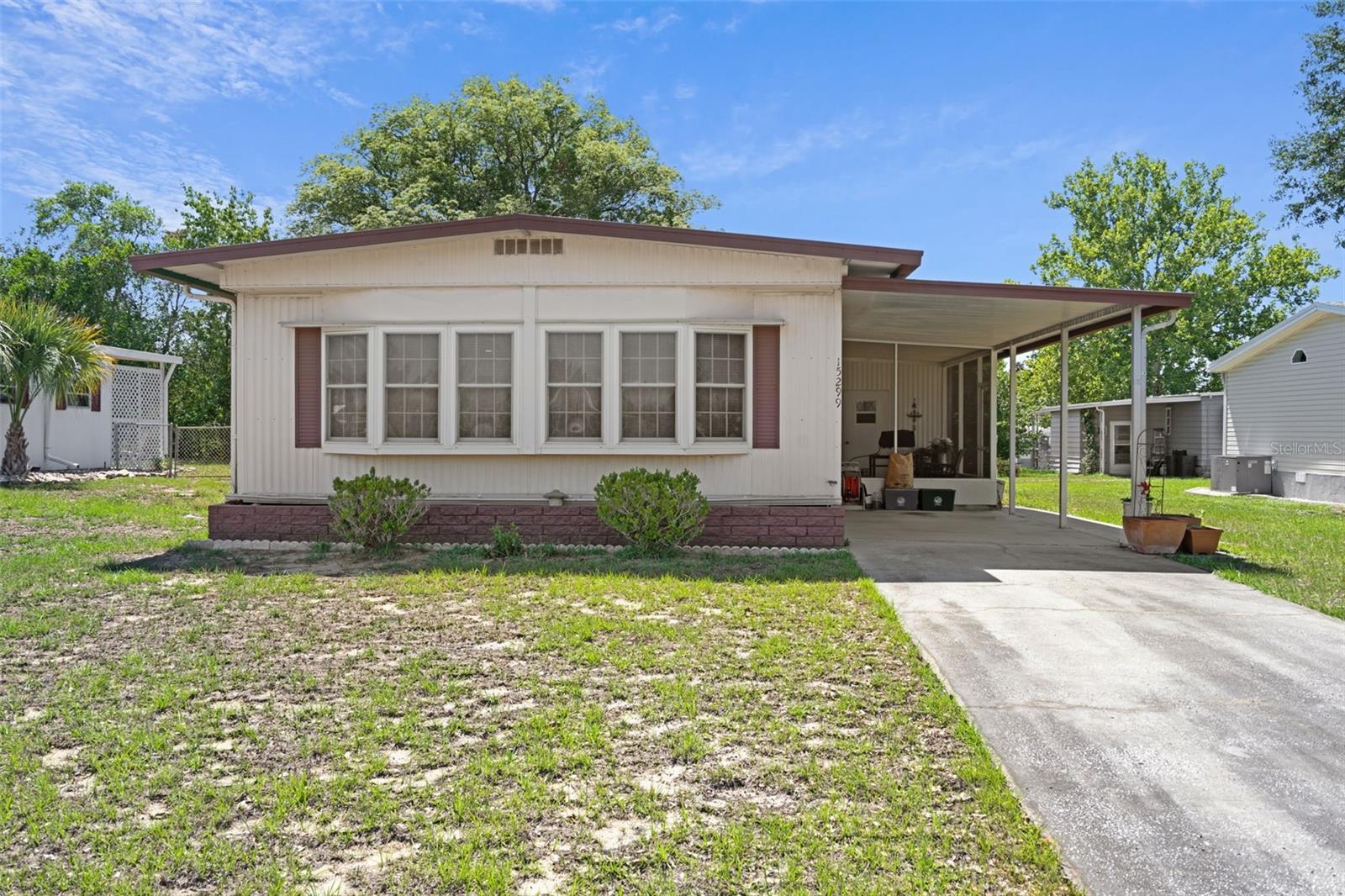 Pride of ownership shines in this impeccably maintained, furnished 2-bedroom, 2-bathroom gem! From the moment you pull up to the epoxy-painted driveway, you'll know this home is special. Step inside to find beautiful, seamless vinyl plank flooring throughout and an abundance of natural light pouring through energy-efficient, double-paned, easy-clean tilt-in windows. The expanded galley kitchen, fully updated and boasting a dedicated pantry and built-in cleaning closets for ultimate organization. Both bathrooms have been tastefully modernized. Newer AC and water heater (2021). The extended utility room features a convenient overhead roll-up door—perfect for a golf cart, workshop, or extra storage. Enjoy your mornings or evenings relaxing on the inviting screened patio. Absolutely immaculate and completely turnkey.  Located in the desirable and vibrant, gated Brookridge 55+ community, enjoy a relaxed Florida lifestyle with access to top-notch amenities including golf (separate membership), pools, clubhouse activities, and more. Close to shopping, restaurants, entertainment, and medical facilities. Low HOA fees and you OWN YOUR OWN LAND.