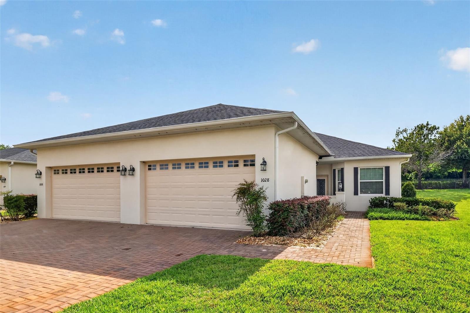 Welcome to 1028 Green Gate Boulevard, a beautifully maintained 3 bedroom, 2 bathroom home in the gated community of The Villas at Green Gate. Designed for easy single-level living, this home offers an open concept layout with high ceilings, natural light, luxury vinyl flooring in the main living area, and a comfortable living/dining room combination that flows into the kitchen. The kitchen features granite countertops, stainless steel appliances, a breakfast bar, ceramic tile flooring, and a walk-in pantry, creating a practical space for everyday living and entertaining. The primary suite includes carpet flooring, ceiling fan, dual closets, and an en suite bath with dual sinks, granite counters, a tiled shower, and rain shower head. Two additional bedrooms provide flexible space for guests, office use, or hobbies, while the large laundry room and 2-car garage add everyday convenience. Enjoy outdoor living from the covered screened rear porch overlooking the backyard. The HOA includes Spectrum internet and cable, lawn care, irrigation, exterior maintenance, painting, pest control, private road, and community pool access. Residents also enjoy access to the Clermont Chain of Lakes, with an optional boat slip purchase available. Located near South Lake Trail, Lake Minneola, downtown Clermont, Winter Garden, Publix shopping, dining, and recreational paths, this home offers low-maintenance living in a convenient Groveland location.