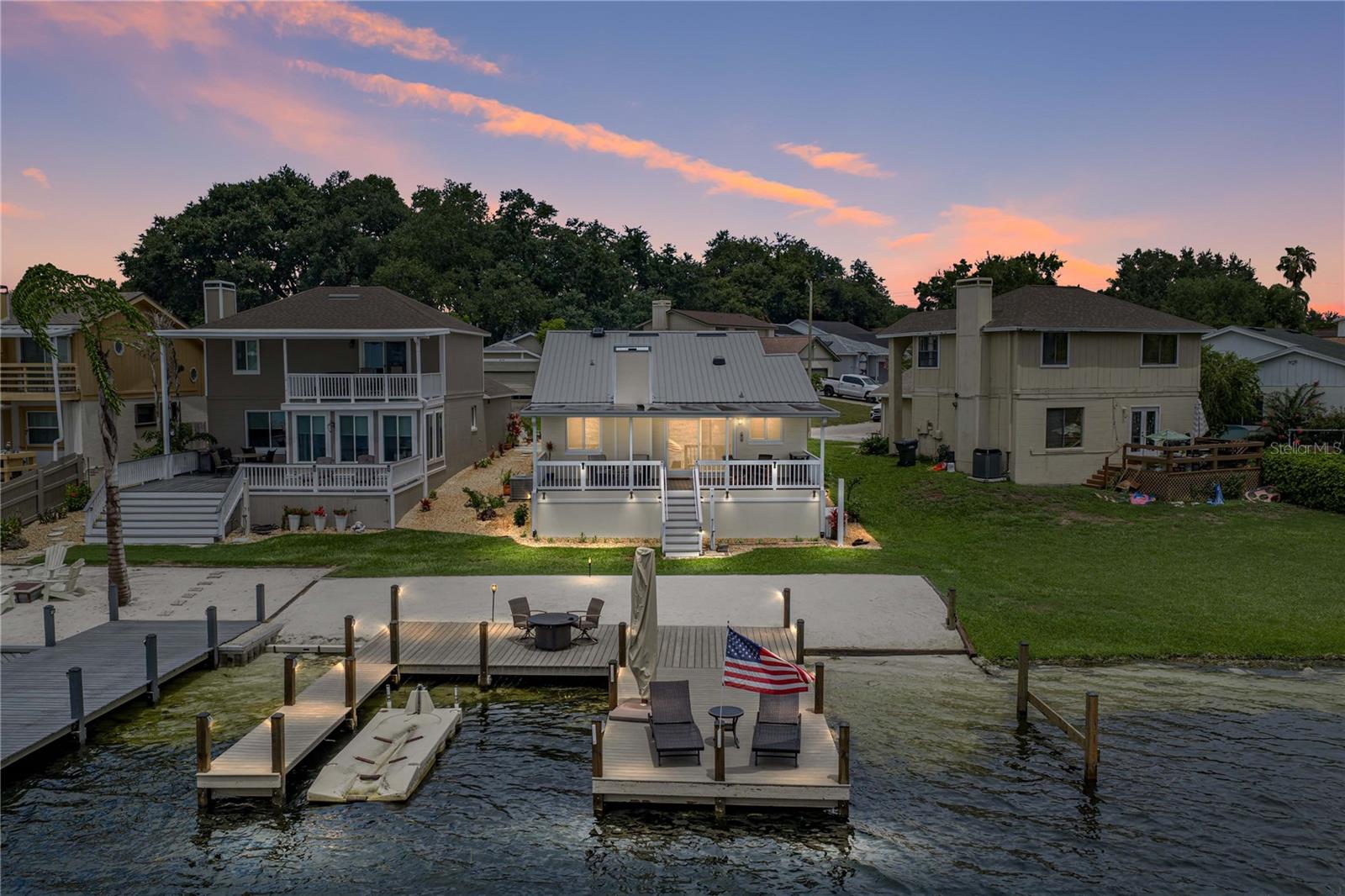 PRESENTING A CHARMING LAKEFRONT RETREAT ON LAKE DEXTER! This beautifully maintained 2-bedroom, 2-bath residence with a 1-car garage offers an exceptional blend of comfort, thoughtful upgrades, and waterfront living. The spacious kitchen flows seamlessly into the open living area, creating an inviting setting for everyday living and entertaining, complete with a modern LED fireplace. Travertine flooring extends throughout most of the home, while the guest bedroom features warm bamboo flooring. Plantation shutters and newer PGT hurricane-impact windows provide added beauty, energy efficiency, and peace of mind.
Additional improvements include a three-year-old energy-efficient metal roof, radiant barrier insulation in the attic, an Amarr triple-steel insulated garage door, and low-maintenance composite decking. The primary bedroom offers two custom built-in closets and a comfortable private retreat.
Step outside to enjoy the patio, composite deck, private dock, and two boat slips on beautiful Lake Dexter. Whether boating, fishing, kayaking, or simply relaxing while taking in the tranquil lake views, this property provides the perfect opportunity to experience the Florida waterfront lifestyle.