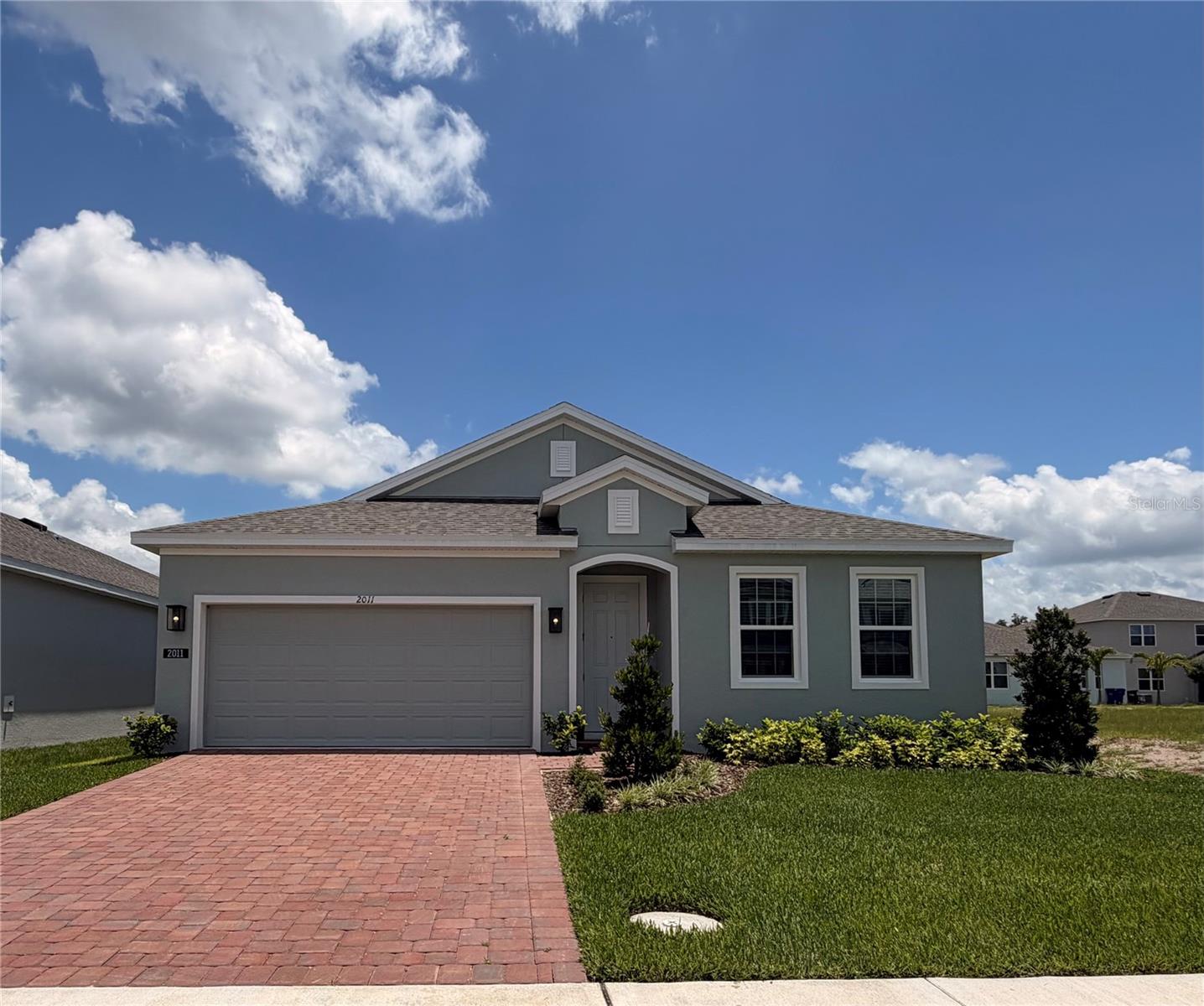 Discover this beautiful move-in ready Kensington Flex home that's ideally located close to Community entrance. This popular plan offers an open-concept layout with impressive 9'4" ceilings and includes 4 Bedrooms and 2 full Baths, plus a separate front Living room/flex space perfect for a home office or den. The spacious Family room opens to a rear covered Lanai, creating the perfect setting for entertaining and outdoor living. Beautiful tile flooring highlights the main living areas, and window blinds are included throughout for added privacy. The well-appointed kitchen features upgraded 42" gray cabinetry, sleek quartz countertops, a large center island, and stainless steel appliances. The private Primary suite includes an en-suite bath with a walk-in closet, dual sinks in an adult-height vanity, quartz counters, a linen closet, and a luxurious tiled walk-in shower. Completing the home is attractive landscaping, and brick paver driveway and lead walk, adding to its curb appeal. Trinity Place offers great amenities including resort-style pool and cabana, a shaded tot lot for the little ones, and a dog park. Community is conveniently located near Shopping and Dining, with easy access to major thoroughfares.