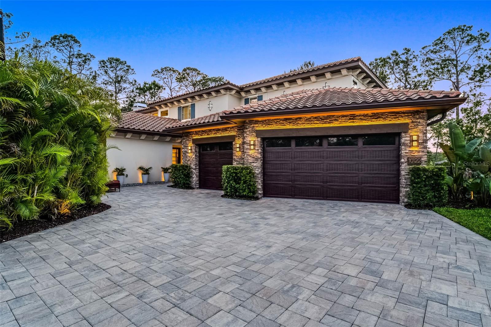 Welcome to 10122 Royal Island Ct, the only two-story Custom-Built Lakefront home in the desirable Royal Cypress Reserve guard-gated community, featuring an exceptional Lakefront setting that embraces nature with No Neighbors to be seen from your private paradise! This is NOT another Toll Brothers model home, rather it’s a resort-style, modern property with an Open Floor Plan featuring 5000 sq ft, including five ensuite bedrooms, a total of 5 full bathrooms, 2 powder rooms, a fabulous separate entertainment area, relaxing swimming pool and spa, and so much more. This Lakefront Masterpiece, built in 2022, includes the ultimate Dock with a 24ft covered Boat Lift and a Double Jet Skit covered lift built with a Tile Roof and all composite decking for years of easy maintenance. Whether you prefer quiet reading by the pool and spa or watching Disney fireworks at night from your custom Dock, this residence is impeccably maintained and has everything to offer. The entrance welcomes you with a serene water fountain leading to the 6ft x 8ft Pivot Glass Front Door that opens to the Foyer, making a unique, truly high-end experience. Enter the open floor plan of the Kitchen – Dining - Grand Room with soaring coffered ceilings and wood inlays. The gas and wood-burning Fireplace is a focal point of the Grand Room as you relax with 12 windows and 9-foot Sliders saturating the room with inviting natural light. The heart of this home is the truly gourmet kitchen with high-end finishes, featuring top-of-the-line stainless steel appliances, a Dual Fuel 48’’ Monogram double oven range, custom dual tone cabinetry, quartz countertops, a 48’’ Stainless Refrigerator, a built-in Miele Coffee Maker, a Wine Fridge, and more. The primary bedroom suite on the first floor boasts unparalleled lake and pool views, a luxurious en-suite bathroom with dual vanities, a walk-in shower with custom Steam controls, a separate soaking Tub, and custom blinds, including two walk-in closets with organizer shelving. The Office on the first level facilitates all your at-home working needs. Creative Laundry room with separate 2nd Refrigerator and Custom Cabinetry is like another Kitchen in quality and design. Two additional bedrooms on the first floor and Two more bedrooms on the second floor, including a second Primary Suite upstairs with Double vanities, Dual Closets, and inviting lake views. The upstairs entertaining area has amazing views from the numerous windows. It features state-of-the-art electronics, including a 165’’ Laser Projection TV System, surround Sound, and Dual Subwoofers to make that movie experience come to life. The custom-built bar makes this entertainment area fun for family and friends to relax. Watch fireworks or enjoy the Lakefront from the 2nd story on the quiet covered Lanai / Porch. The saltwater system Pool and Spa is warm and inviting with its dark interior finish and elevated Spa, as it overlooks the large covered Lanai with a built-in summer kitchen with separate Grill, Refrigerator, entertainment sink, and ample Bar seating. Situated adjacent to Disney property, in the esteemed community of Royal Cypress Preserve, residents have access to a wealth of amenities, including a zero-entry pool, clubhouse with catering kitchen, fitness center, dog park, and playground. Located near world-class dining, shopping, local theme parks, unlimited entertainment options, and top-rated schools. Don't let this showcase home pass, call today for a showing!