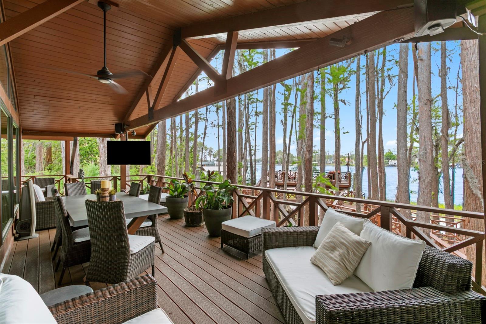 Welcome to the quintessential "Old Florida" lake house - set on sought-after Lake Keystone, a premier ~434-acre private ski lake in Odessa. Situated on 1.16 acres with nearly 220 feet of shoreline, this property offers unmatched privacy and a true waterfront lifestyle. A long private drive guides you to a stunning setting among historic cypress trees, featuring a one-of-a-kind boardwalk, two grandfathered-in observation decks, and a boathouse with lift. Outdoor living is exceptional with a screened-in heated saltwater pool and spa, expansive yard, basketball court, fire pit, and a full outdoor kitchen with grill and Big Green Egg. The vaulted back porch captures incredible lake views, complemented by mature landscaping and extensive outdoor lighting. Inside, the main living level offers an open layout with walls of windows and exposed beams. The primary suite features a walk-in closet, additional built-ins, and a spa-like bath. 2 additional bedrooms and 2 additional bathrooms complete this level. The lower level includes a secondary living room with fireplace and pool access, full bath, laundry/kitchenette, and a fourth bedroom or office. Crossing through the 3-car tandem carport, you will find a climate-controlled storage room with mini-split and cedar closets to add functionality.
Notable upgrades include Control4 smart home automation, security cameras throughout the property, Generac whole-house generator (2026), impact windows, metal roof, composite decking, water filtration system, and more.
A rare opportunity to own a truly special lakefront property that feels worlds away, yet minutes from Tampa. Full upgrades list available upon request.