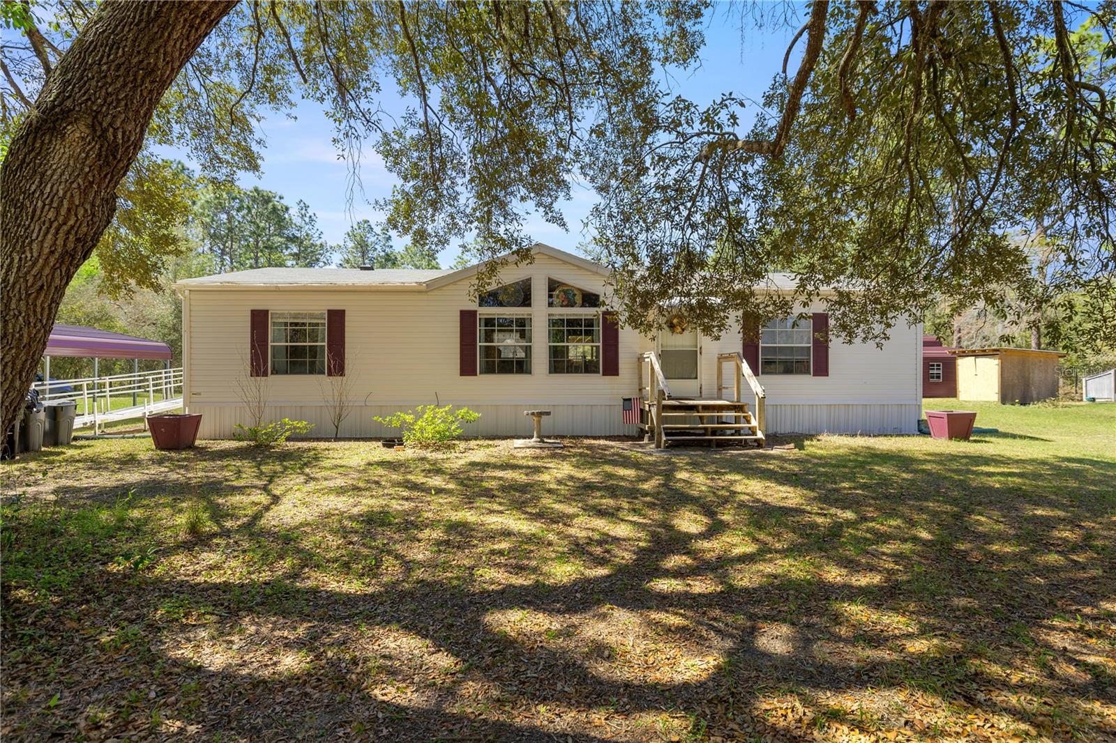 Escape to the countryside and discover this charming 3-bedroom, 2-bathroom doublewide home on 1.25 fully fenced acres in Williston Highlands. Built in 2002, this bright and inviting home offers over 1,400 sq. ft. of living space with a desirable split floor plan. Recent updates include a newer roof, appliances, flooring, and kitchen cabinets. Interior features include freshly painted walls, updated bathrooms. Outside, you'll find a spacious wooden deck, a 2-car carport next to the home, and a large outbuilding that can serve as a workshop, barn, or storage for your toys. With plenty of space for your animals to roam, this property is perfect for peaceful country living!