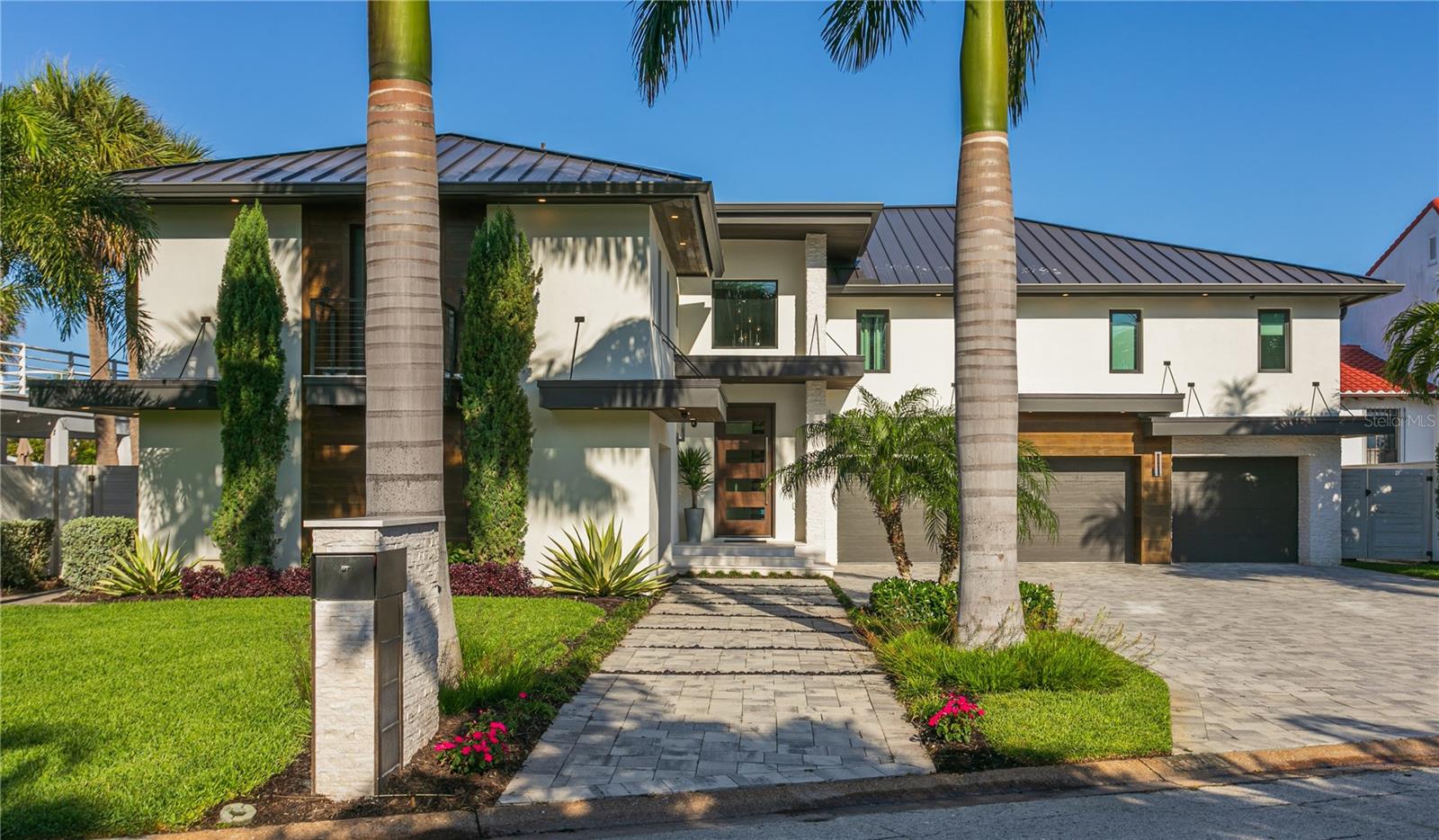 MASTERPIECE OF WATERFRONT MODERN LUXURY!  This stunning, award-winning, architecturally designed Smart Home is a “Must See,” a true gem in Florida luxury real estate.  The attention to detail in every aspect of this property is simply breathtaking.  Boasting an open floor plan with spectacular water views from nearly every room, state-of-the-art technology, custom finishes, a grand two-story stone floor-to-ceiling foyer with a floating staircase, and a chef’s dream kitchen with custom cabinetry and Wolf/Sub-Zero appliances. The luxurious owner’s suite offers a spa-like bathroom w/his & her separate amenities, and a private sunroom with floor-to-ceiling glass overlooking the bay. This extraordinary 5,113 sq ft home, and an additional 1,200 sq ft in covered patios under roof, is thoughtfully designed for year-round indoor/outdoor living and entertainment on 90’ of west-facing water frontage providing incredible sunsets over Boca Ciega Bay. This well-appointed custom home includes: 5 bedrooms, 5.5 baths, 4 car garage, ensuite guestrooms, two living rooms, wet bar complete with built-in 130 gal saltwater fish tank, indoor sauna/workout room, sparkling saltwater pool/waterfalls, above-ground spa, 12,000 lb boat lift & a separate 55 ft boat slip, concrete block/tie-beam construction, hurricane impact windows/doors, outdoor misters, elevator, lush tropical landscaping, 7' privacy wall, and smart home tech to monitor and control the home's security and automated systems from anywhere in the world.  Situated on an incredible lot in St. Pete Beach, with easy access to nationally top-ranked sandy beaches and the Gulf-of-Mexico, 5920 Bahia Honda Way N is the epitome of luxury resort-style living in Florida.  This property has grandfathered status offering inexpensive flood insurance as well as credits with homeowners insurance!  Buyer to verify: the home was originally built in 1982 and was completely rebuilt top to bottom in 2020 including exterior walls. Don't miss the opportunity to make this exceptional property your own and indulge in the ultimate in modern elegance and comfort.