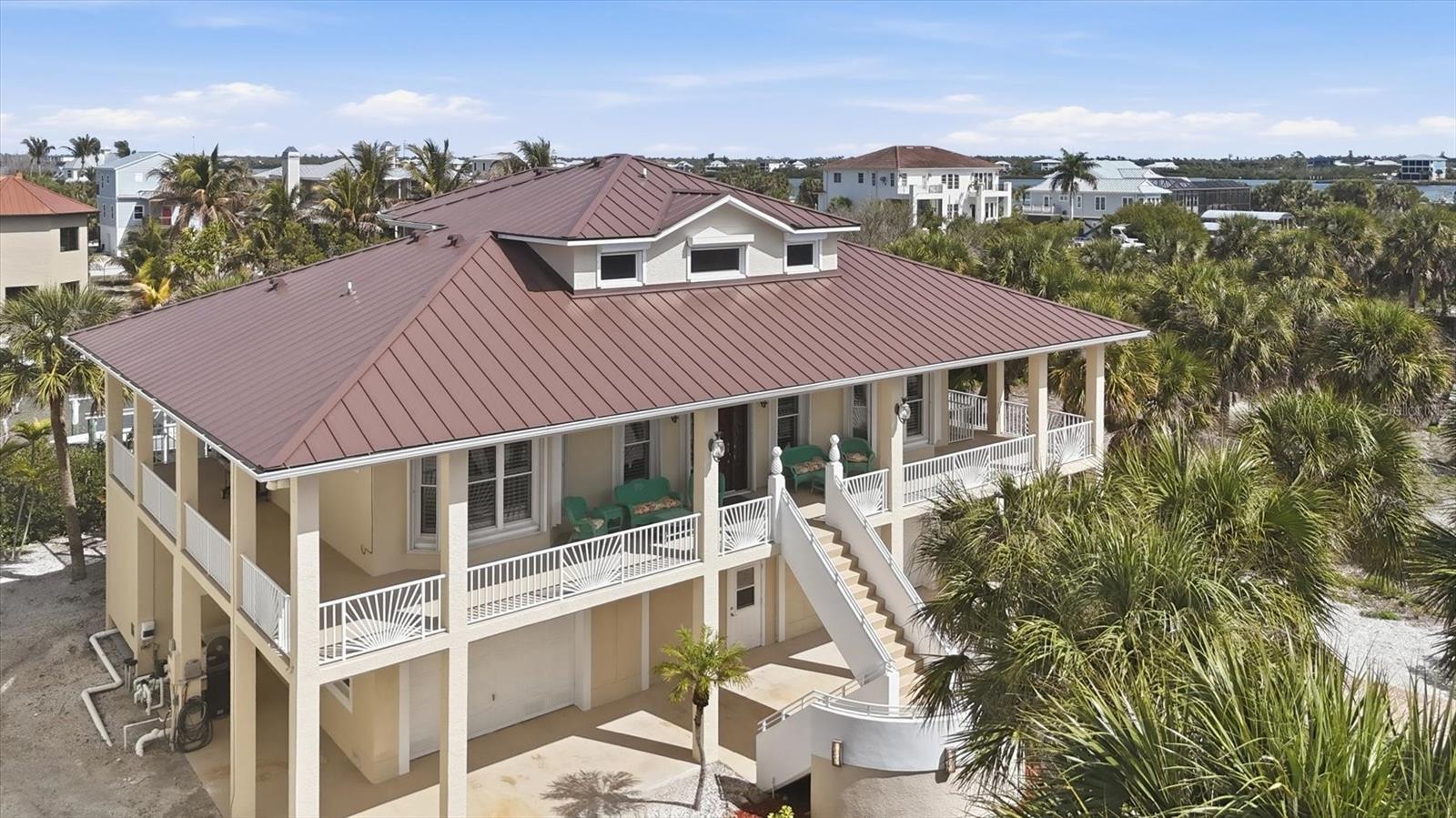 Palm Island – A Beach lover and Fisherman’s dream come true. This concrete 3-story home (one of the few concrete homes on the island) brags of space and easy living. With its location on a deep-water canal that leads directly to the intracoastal waterway, it’s a quick boat ride to some amazing fishing inshore and offshore. On the island, a short golf cart ride takes you to the quiet, shell-lined beaches for a lazy day in the sun or beautiful sunrises or sunsets. Look for some shark teeth while you are on the beach! Downstairs between spacious garages is a game room/hobby room for families of all ages. The beautiful pool sits just outside the game room with plenty of covered space for the non-sun lovers and open space for those that do love the Florida sun! The pool has a sun shelf and a hot tub. On one side, there is room off one of the garages that has the beautiful pool view and can be used as an office or extra bedroom and the area has a full pool bath just off the pool. On the other side of the pool is a storage/fishing room. The dock has two boat lifts – one for your fishing boat and the other for your fun jet ski. As you ascend up the steps to the main living area, a wraparound porch awaits with multiple places for sitting, grilling and entertaining. As you enter the front door, there is an open room for dining and relaxing with a sitting area that has a half bath. The kitchen boasts of lots counter space and easy flow and is open to the dining area for easy entertaining and family meals. The two bedrooms off the living area are on each side of the full bath. Upstairs you’ll find a private, expansive master bedroom and bath with two large closets. Off the master suite, there is another covered porch with a view of the intercoastal. With concrete construction, hurricane shutters and a new metal roof installed in 2023, this home blends durability with coastal sophistication. Come step into a world where life slows down and peaceful living take center stage.