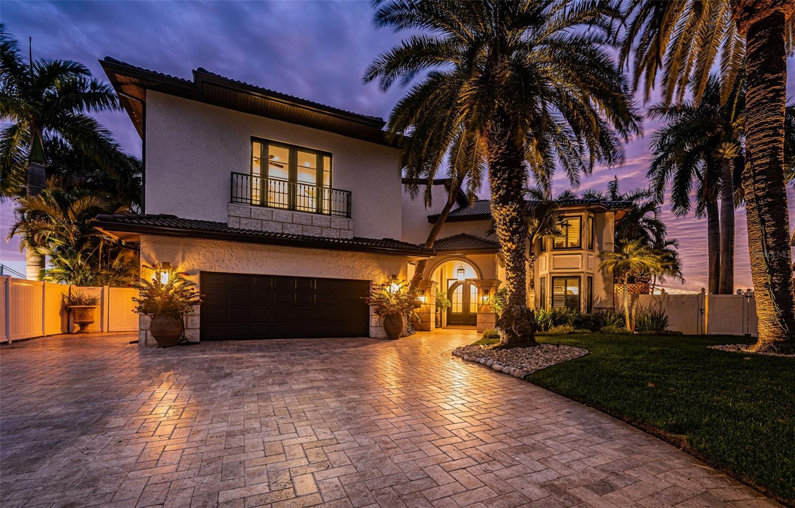 Under contract-accepting backup offers. COASTAL CONTEMPORARY LUXURY WITH A UNIQUE TUSCAN APPEAL! Step into a waterfront estate that will raise your senses of sight, sound and touch! Originally built in 1961 but has been rebuilt in 2006. Exquisitely detailed exterior finishes introduce a stately 12ft-high covered entry with splendid arched steel double doors. Inside, discover a spectacular, intricately woven floorplan with dramatic arches, brilliant custom wall finishes, elegant wood flooring, lovely alcoves, superb built-ins and extraordinary woodwork. The expansive great room with its substantial 11ft-high wood ceilings, radiant lighting and cast stone fireplace wall with built-ins, is defined by an amazing wall of 9ft tall sliding glass doors that deliver unforgettable views of the waterfront. The sumptuous open-concept gourmet designer kitchen is a feast of culinary form and function – with aged wood-beamed ceilings, thick Italian marble surfaces, coastal-white raised-panel cabinetry, Wolf/Miele appliances, Bertazzoni gas cooking center, a 3-unit refrigeration wall, full-height wine chiller, huge hammered-copper exhaust, inspired designer lighting, and an incredible island bar with copper farmhouse sink and Italian Marble Waterfall counters (built over a sturdy ancient altar!). You’ll appreciate the fine butler’s pantry and adjacent full-size luxury pool bath. The generous waterfront dining area features two access point to the pool deck. Overlooking the water and opening to a sizable covered deck, the large owner’s suite with dedicated seating area is a welcoming way to begin and end your day. The owner’s bath enjoys beautiful Italian marble surfaces, dual vanities, a dedicated morning bar, an eye-catching all-marble rainshower with digital controls, and a fabulous walk-in closet with built-ins and wonderful center dresser. Upstairs you’ll find an astonishing custom game room with luxurious professional bar; boasting posh wainscoting, rich granite surfaces, custom cabinetry, extensive beverage chilling/refrigeration and surround sound, this will be everyone’s favorite stop to watch the ball game. Step out to the 42ft-wide, 400sqft+ covered balcony and enjoy commanding, panoramic views of the waterfront. Offering an alternative experience, the waterfront fitness room and casual sitting area is a great place to exercise and relax. Two spacious bedrooms share a 20ft-wide waterfront balcony with terrific open water views. A 3rd bedroom is joined to an inviting common sitting area, while the resplendent 4th bedroom provides a Juliette balcony. All bathrooms are lavish in their appointments. Out back you’ll be captivated by a dazzling waterfront setting – a towering 13ft-high 400sqft covered deck with roomy lounging/dining areas and built-in gas cooking center, transitions to a striking Pebbletec pool/spa and your sweeping open water vistas. Impressive travertine paver walkways run the width of the home and are complemented by lush, private subtropical landscaping. You’ll love the dedicated covered waterfront dining area – ideal for large gatherings. The exceptional composite dock features a true rarity, two permanently covered boat lifts with walkway access to both sides of both lifts! Lighting automation, whole house audio, solar electric power and battery backup, and so much more. A magnificent home and tremendous value for all it has to offer. Dimension are estimates, buyer to verify.
