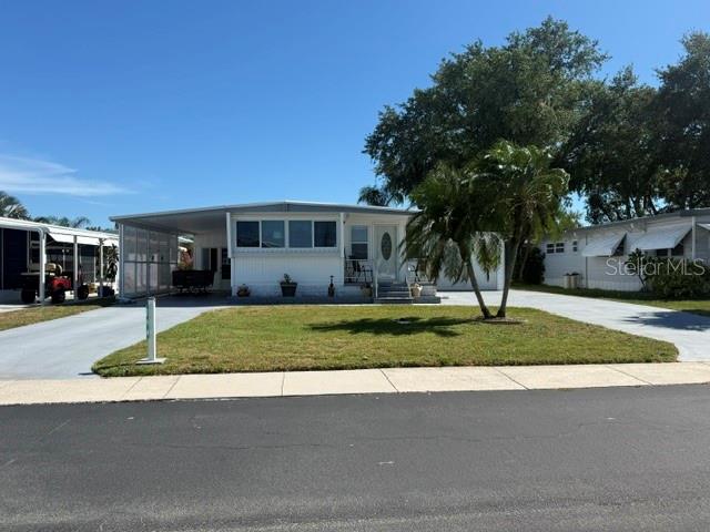 Only steps to access Lake Tarpon from this 2 bedroom home with plenty of room to store your boat in the oversized garage. All of this is located in the highly desirable Lake Tarpon Mobile Home Village 55+ community where you OWN YOUR LAND. This cozy well maintained 2BR/2BA manufactured home, set on a generous 62' x 97' lot, boasts two driveways on opposite sides of the house. One leads to an oversized garage (24 x 35), the other drive leads to a carport and spacious enclosed lanai. This move-in ready home fits your need, whether for a full-time residence, seasonal retreat, or investment opportunity. Owners are also open to a rental arrangement, feel free to contact the listing agent. Enter the home into the generously sized bright Florida room which perfect for dining, living, TV room, or entertaining space. The sliding glass doors lead into the living room which is open to the kitchen. Just down the hall is a bath, second bedroom and a primary bedroom with a king-sized bed and an ensuite bath. The door off the kitchen leads to a spacious screen room where you can relax in the evening breeze. There is adequate kitchen and counter space to prepare your favorite meals with plenty of storage to meet your needs. This home has plenty of closet space as well. With an exceptionally low HOA fee of just $109.69 monthly, residents own their own land, enjoy access to a lively golf cart friendly community that enjoys many social activities and includes a private boat dock and fishing pier on Lake Tarpon, a large remodeled heated pool with sundeck and covered seating areas, clubhouse with full kitchen, stage, sound system and screen, card room, library, billiard room, shuffleboard, bocce ball, horseshoes, golf practice net, as well as a picnic and grilling area. There is an area used for pickleball. Easily accessible to many dining options, golf courses, shopping, parks, entertainment and beautiful Gulf beaches as well as two major airports. This is an outstanding opportunity to own a well-cared for home in one of the area’s most popular 55+ communities. Schedule your showing today.