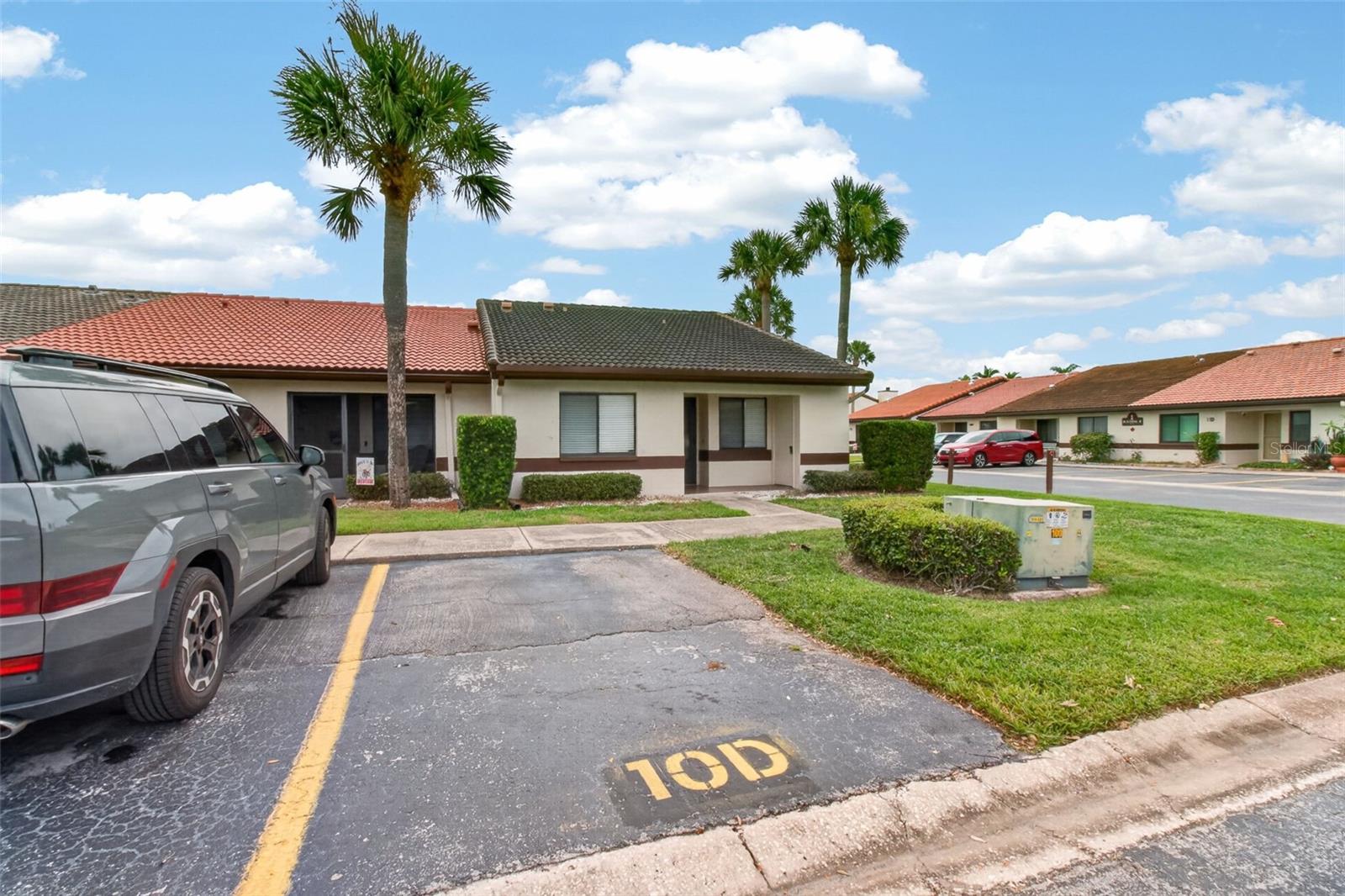 Bright and welcoming end-unit 2-bedroom, 2-bath villa in Rosetree Village featuring an enclosed Florida room perfect for year-round enjoyment, work-from-home space, or additional living area. Natural light fills the home, and the split-bedroom layout provides excellent privacy. Both bedrooms include walk-in closets, and the kitchen offers ample cabinetry, a breakfast counter, and an easy flow into the dining area. A hallway storage closet and washer and dryer add everyday convenience. Major upgrades include a newer AC unit (approx. 2 years old), newer Wi-Fi–enabled water heater with leak detection/shut-off, solar-powered attic fan, and Hurricane/Storm Screens for added protection and energy efficiency. A screened porch is located at the rear of the home, while your assigned parking space sits directly in front of the unit, providing unmatched convenience for daily living. The low HOA fee covers water, sewer, trash, basic cable, grounds maintenance, and exterior painting. Community amenities include two pools, basketball court, playground, community room, and optional storage for a small boat or trailer. Pet-friendly, no age restrictions, and short-term rentals allowed. Centrally located near beaches, shopping, dining, and Tampa, Clearwater, and St. Pete airports. Schedule your private tour today.