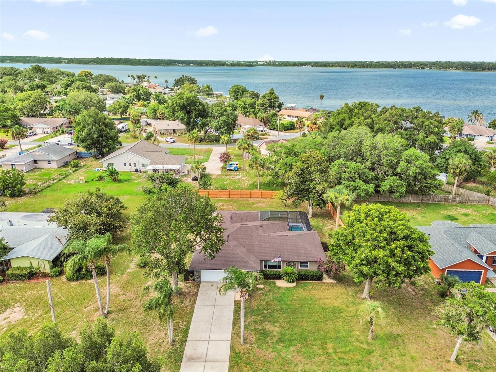 CHAIN OF LAKES ACCESS! Welcome to this beautifully remodeled 3-bedroom, 2-bath home nestled in a peaceful community of boating enthusiasts with access to the Harris Chain of Lakes. Residents enjoy access to a private boat ramp through the voluntary HOA for just $100 per year, making it easy to spend your days fishing, boating, skiing, or exploring Central Florida's renowned waterways. From the moment you arrive, you'll appreciate the extensive updates and pride of ownership throughout. Major improvements include a new roof (2022), HVAC system replacement (2018), 11 replacement windows (2017), inground swimming pool and deck (2017), screened pool enclosure (2018), and a new exterior door (2025). Inside, the home has been tastefully remodeled with porcelain wood-look tile flooring throughout the majority of the living areas, while the bedrooms feature a combination of bamboo and wood laminate flooring. The spacious living room is highlighted by a cozy wood-burning fireplace, creating the perfect gathering space for family and friends. The updated kitchen features painted white cabinetry, stainless steel appliances, a French-door refrigerator, and a smooth-top range. A stylish barn door separates the laundry room, adding both character and functionality. The primary suite offers a custom California Closet system, maximizing organization and storage. Step outside to enjoy Florida living at its finest with a covered lanai overlooking the private, fenced backyard. The sparkling swimming pool is enclosed within a birdcage and includes a pool cover to help retain heat and extend swimming enjoyment throughout the year. Additional features include a storage shed, a private well currently used for irrigation and outdoor water use, and the potential to expand into a full sprinkler system if desired. If you're looking for a move-in ready home with significant upgrades, a private pool, and coveted Chain of Lakes access, all within a quiet neighborhood surrounded by fellow boating enthusiasts, this property deserves a spot at the top of your list.