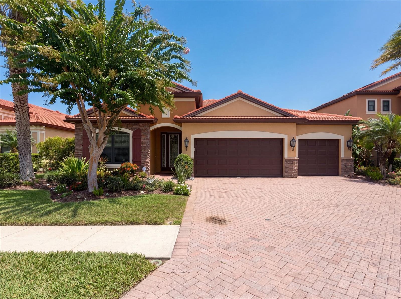 Virtually Staged. 2575 Grand Lakeside Dr is a one-story Palm Harbor home built in 2015 with a tile roof and paver driveway. The kitchen features quartz countertops, stainless steel appliances, dark wood cabinetry, and a large center island that opens to the great room for connected living. Adjacent dining and living spaces carry tile flooring and abundant natural light. The primary bathroom offers a dual-sink vanity and a separate glass shower, with additional full bathrooms serving the remaining bedrooms. A screened lanai surrounds an in-ground pool and covered patio that overlook the pond, extending the living space outdoors. A three-car garage completes this well-maintained residence with practical amenities throughout.. Included 100-Day Home Warranty with buyer activation