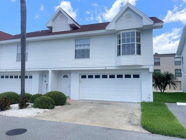 Enjoy coastal living in this bright and airy 2-bedroom 2-bathroom townhome located in desirable Indian Shores. The open concept floor plan features cathedral ceilings and allows for abundant natural light. Laundry coset is conveniently located inside, and bedrooms are spacious. Master suit offers a walk-in closet and on suit bathroom.  An oversized garage provides ample room for parking, storage, work bench and beach gear. Residents enjoy a well-maintained community with a sparkling pool, and a day-use boat dock for easy access to the intracoastal. Public beach access is located directly across the street, making it effortless to spend your days enjoying the sand, surf, and sunsets. Whether you're seeking a primary residence to make your own, vacation getaway, or investment opportunity, this inviting townhome offers the ideal combination of comfort, convenience, and beach-community amenities.