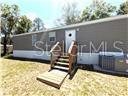 Welcome home to this charming, completely refurbished 2-bedroom, 2-bathroom single-wide manufactured home built in 2017. Nestled on a level 0.19-acre lot in the peaceful Circle M Ranchettes / Backwaters Heights community, this property offers a serene setting with absolutely no HOA fees, no lot rent, and a highly desirable "No Flood Zone" designation!  Step inside to an inviting, open-concept living, dining, and kitchen area—great for entertaining. The thoughtful split-bedroom floor plan ensures maximum privacy. The spacious primary bedroom features a generous walk-in closet and an en-suite bath, while the comfortable guest bedroom on the opposite side enjoys convenient access to the second full bath. Additional interior details include updated flooring, crown molding, and a dedicated inside laundry room.  The exterior features a fully fenced yard, offering a fenced yard  for pets or play, along with a heavy-duty 8x20 storage container to easily handle all your tools and outdoor gear.  Location is everything! You are just minutes away from world-class outdoor recreation, including boating and bass fishing on Lake Rousseau, kayaking the Withlacoochee River, tubing down the pristine Rainbow River, and exploring Florida’s famous natural springs. Quick, easy access to local shopping and dining makes this the perfect full-time residence, winter getaway, or investment property. Schedule your showing today!