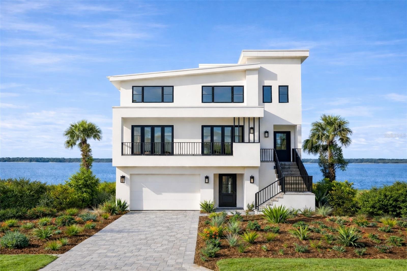 One or more photo(s) has been virtually staged. Pre-Construction. To be built. Pre-Construction. To be built. Experience the pinnacle of modern waterfront living in this exceptional new construction residence, thoughtfully designed to capture sweeping open water views and deliver uncompromising luxury at every turn. Built with solid all-block construction and outfitted with impact-rated doors, sliders, and windows, this home offers both peace of mind and enduring quality, further enhanced by a whole-house generator and natural gas service. A dramatic open-concept floor plan seamlessly connects the main living spaces, creating an ideal setting for both everyday living and grand entertaining. The chef’s kitchen anchors the home with an elite appliance package, expansive center island with seating for five, custom cabinetry, and a large walk-in pantry, all overlooking the water for an inspired culinary experience. A climate-controlled, glass-enclosed wine room adds a striking architectural statement and refined touch. This residence features four spacious ensuite bedrooms, plus a versatile fifth bedroom ideal for a gym, game room, or guest suite, along with a dedicated study/office for work-from-home convenience. The owner’s suite is a private retreat, complete with a covered waterfront balcony, a spa-like primary bath showcasing double vanities, a freestanding soaking tub, and a glass-enclosed shower. An impressive 17’ x 15’ boutique-style wardrobe with center dressing island completes the suite. Outdoor living is elevated with two distinct entertainment areas—one open-air and one covered—perfect for sunset gatherings. The resort-style pool and spa create a private oasis overlooking the water, ideal for relaxing or entertaining year-round. Additional highlights include a five-car garage, elevator, generous laundry room, and a thoughtfully designed floor plan that balances luxury, function, and lifestyle. This extraordinary waterfront home is a rare opportunity to enjoy new construction, open water vistas, and refined coastal living at its finest. If all of this isn't enough to entice you, for a limited time, the seller will allow buyers to choose fixtures and finishes to satisfy their tastes. The land can also be purchased seperately and independently from the home build package descibed above.