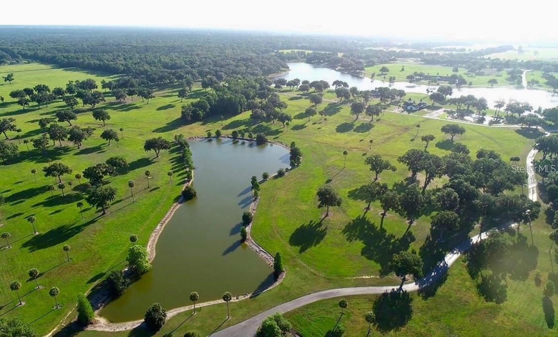 Luxury Equestrian Homesite in Silverleaf Hills – Ready for Your Dream Ranch One of the most stunning parcels available in Silverleaf Hills, this exceptional homesite offers the perfect opportunity to build your dream estate or horse ranch in the same prestigious community as the 2024 Kentucky Derby winner was trained. This beautiful property is build-ready, featuring an existing well and classic 4-board fencing, ideal for equestrian use. The land surrounds a fully stocked shared pond, creating a peaceful natural setting frequently visited by otters, turtles, birds of prey, wild turkeys, tilapia, and other native wildlife. Silverleaf Hills is a newly established gated equestrian community spanning approximately 765 acres of rolling countryside. Residents enjoy an elegant blend of natural beauty and thoughtful planning with: Secure gated entrance Paved roads throughout the community Underground utilities Sensible deed restrictions Extensive bridle trail easements throughout the entire community The landscape showcases rolling hills, majestic Granddaddy Oaks, and crystal-clear spring-fed lakes, providing breathtaking views and a true horse-country atmosphere. The property’s picturesque pond offers the perfect setting for adding a private dock or fountain, enhancing the already tranquil environment. An additional neighboring parcel is also available, allowing a buyer the rare opportunity to own over two-thirds of the pond and create a larger equestrian estate. Lot #15 (11.85 acres) is also available for purchase – See MLS #OM720468. When combined with this parcel, the total acreage would be approximately 22.95 acres. True to its equestrian-first vision, Silverleaf Hills uniquely allows barns to be constructed prior to homes, making it perfect for horse owners ready to establish their facilities first. The location provides outstanding access to Central Florida’s premier equestrian venues: 10 minutes to Florida Horse Park 25 minutes to the World Equestrian Center in Ocala Minutes from The Villages for shopping, dining, and entertainment Convenient access from both US-301 and Hwy 42 ensures smooth travel for horse trailers and daily commuting alike. Custom luxury homes are already beginning to rise throughout the community, creating a refined and cohesive equestrian environment. Ride your horses along the community’s dedicated bridle trail easements, enjoy the serenity of protected natural landscapes, and design the equestrian estate you’ve always envisioned.