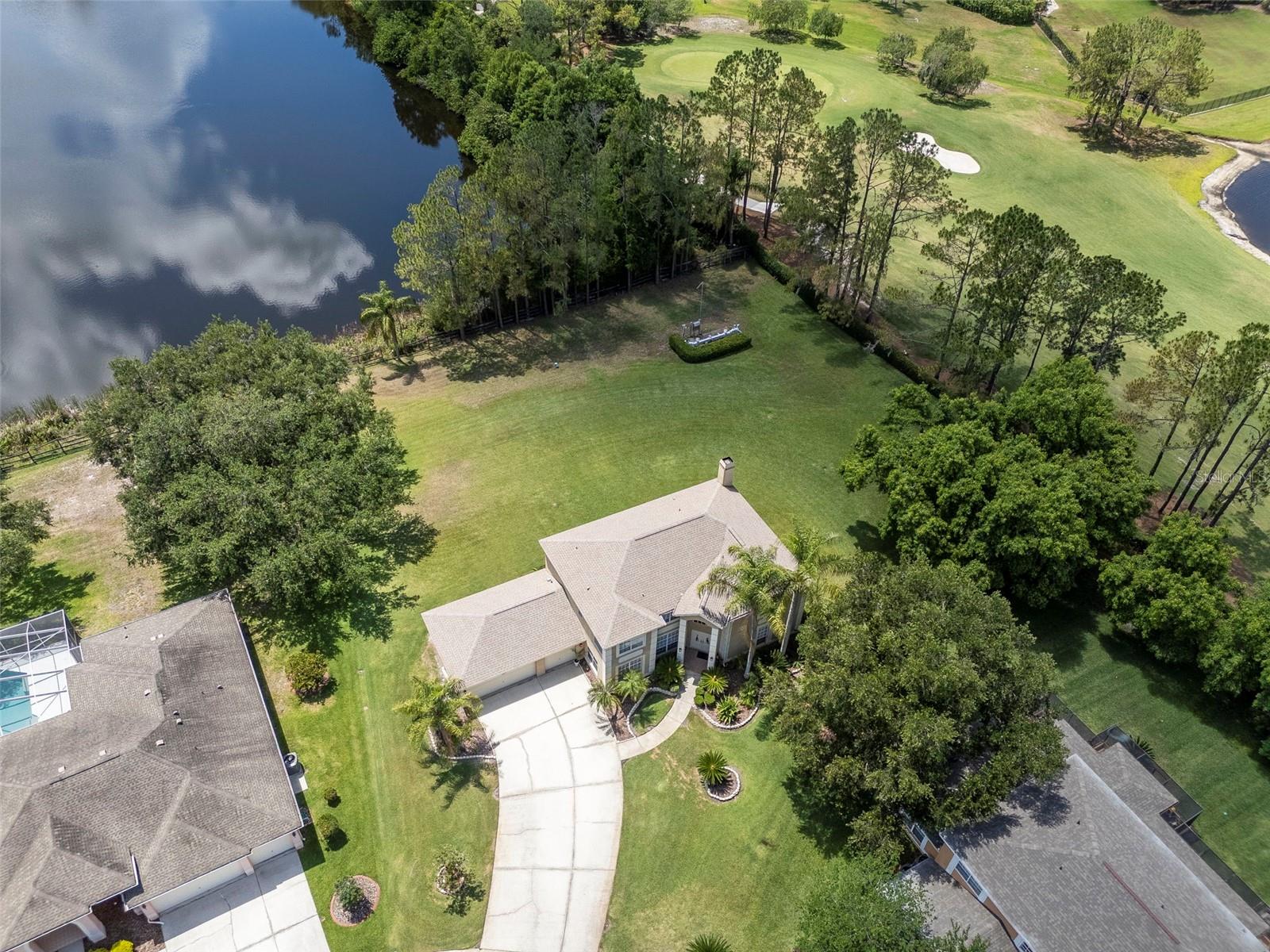 Welcome to one of the most captivating homes in the highly sought-after community of Calusa Trace, where timeless elegance, an exceptional homesite, and breathtaking natural beauty create a truly unforgettable living experience. Perfectly positioned on a pristine water-view and conservation lot, this stunning residence offers a rare combination of privacy, serenity, and an expansive backyard that is nearly impossible to find in today’s market. Surrounded by tranquil water views, protected woods, and spectacular sunsets, this property feels like your own private nature retreat while still being conveniently close to everything Tampa has to offer. Boasting 3,276 Sq.Ft. of beautifully designed living space, this elegant two-story home features 5 beds, 2.5 baths, a versatile flex room, and a 3-car garage equipped with plumbing and a separate exterior door positioned for a future pool bath conversion. From the moment you arrive, the impressive double-door entry welcomes you into a grand foyer highlighted by soaring ceilings and a dramatic wood staircase with gorgeous wrought iron railing, creating an immediate sense of elegance and warmth. Designed for both entertaining and everyday living, the thoughtful floor plan offers a versatile flex space located just off the formal dining room, ideal for a home office, reading lounge or coffee room. The spacious family room, centered around a cozy wood-burning fireplace, showcases breathtaking views of the expansive backyard and protected conservation area beyond. Tons of windows flood the home with natural light and seamlessly connect the indoor and outdoor living spaces, allowing you to enjoy incredible water and sunset views from the comfort of your own home every evening. The heart of the home is the spacious kitchen, perfectly designed for gathering and entertaining, featuring gorgeous granite countertops, wood cabinetry, newer stainless steel appliances, abundant counter space, and a bright breakfast nook overlooking the remarkable backyard and peaceful water views. Words and pictures simply cannot capture the beauty and tranquility this outdoor setting provides. Conveniently located on the first floor, you’ll also find a guest bedroom, half bath, and laundry room. Upstairs, the luxurious owner’s retreat is accessed through elegant French doors and offers a spacious sitting area, two walk-in closets, and a beautifully appointed ensuite bathroom featuring dual granite vanities, a relaxing garden tub, separate walk-in shower, and private water closet. The additional bedrooms are generously sized, including one with its own walk-in closet, while the secondary bathroom features double vanities, granite countertops, and a bathtub designed for comfort and convenience. Additional upgrades include two A/C units replaced in Nov-2020, a newer dryer, and updated S/S appliances. Residents of Calusa Trace enjoy NO CDD fees and access to the highly acclaimed Steinbrenner HSl district. Conveniently located just minutes from St. Joseph's Hospital-North, and about 20–30 minutes from Tampa Int. Airport and downtown, this home offers the perfect blend of tranquility and convenience. Nature lovers will appreciate the peaceful surroundings, where deer, sandhill cranes, and native wildlife are often seen from the backyard. Opportunities to own a homesite this special in such a premier location rarely come available. Schedule your private tour today and experience the lifestyle this extraordinary home has to offer.