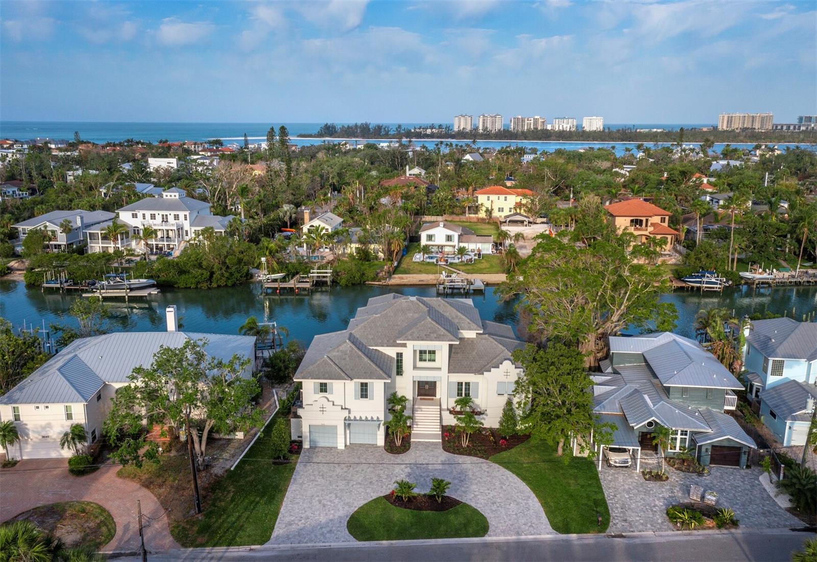 LARGE PRICE REDUCTION on this Bay Island Waterfront NEW CONSTRUCTION, move in ready!!! Situated on 1/3 acre with 102 feet of wide canal waterfront and no bridges to the bay. The 4,711 square foot home is solid block construction on all levels. The house has been thoughtfully designed, maximizing privacy and use of space. The main level features a designer kitchen with an open floor plan to the great room, a separate office, two covered terraces and a summer kitchen. The spacious primary suite is also on the main level with dual closets and a sumptuous bathroom featuring a large walk in shower and separate soaking tub. Mid level you will find 2 en-suite bedrooms, and the upper level boasts a clubroom with wet bar, a second primary suite, and an outdoor covered terrace to enjoy the sunset views. Other notable features include high ceilings with an abundance of natural light, an elevator to all levels, 3-car garage (one tandem), and a heated saltwater pool & spa. Constructed by premier builder Mike Voigt and interiors by acclaimed designer Angela Rodriguez, this house will check all the boxes of your dream waterfront home. The property was listed pre-construction. The days on market are reflective of the entire construction process and certificate of occupancy was granted end of March 2025.