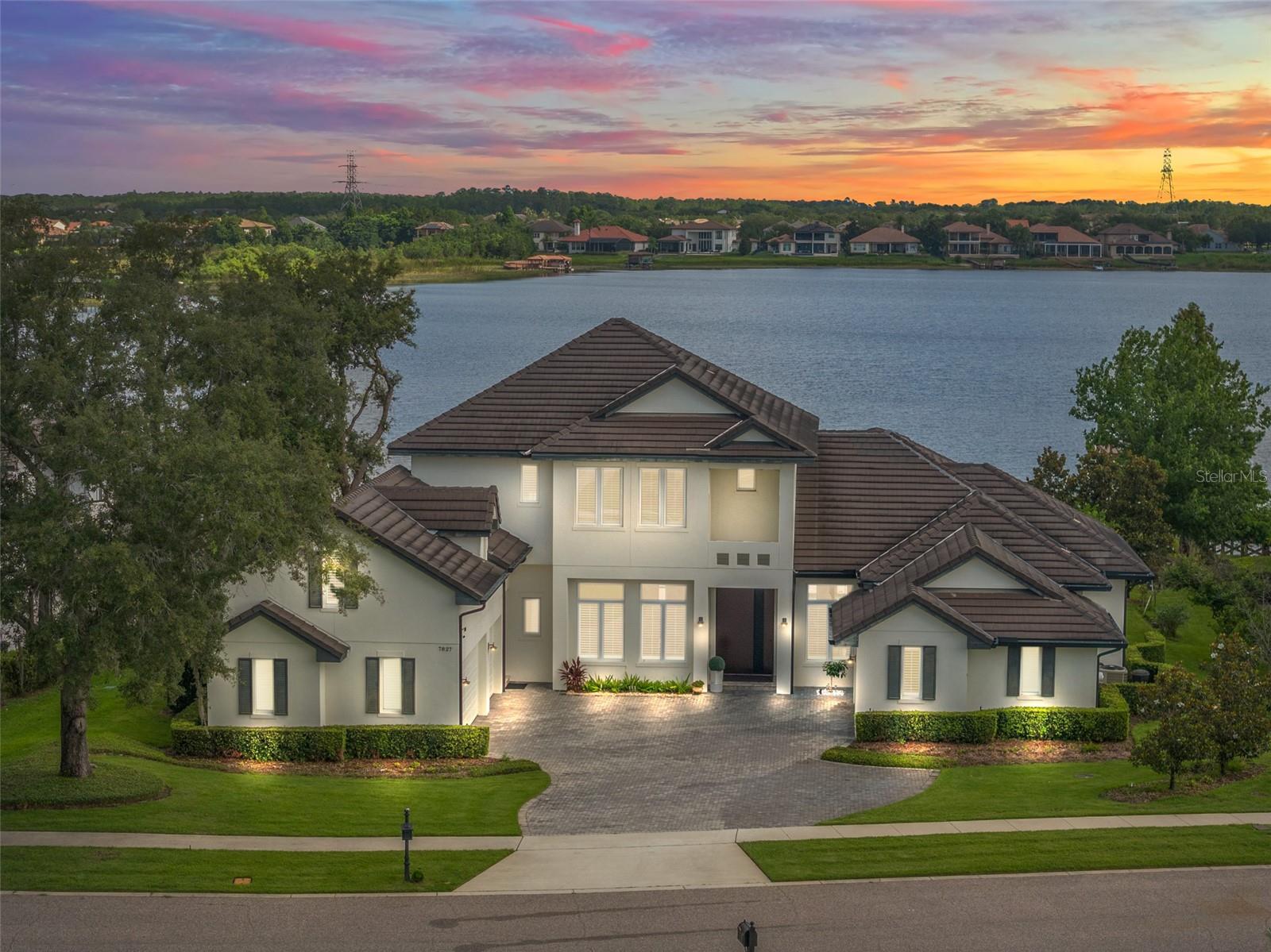 Nestled along the southern shoreline of Lake Hancock amidst an enclave of custom-built lakefront homes, within the private gates of
the exclusive Isles of Lake Hancock, this newly remodeled masterpiece offers the finest in materials and craftsmanship and is ideally situated on 110’ of
pristine shoreline frontage with the lake’s most expansive water views. The entryway involves monumental scale and effortless, whisper-quiet operation with the spectacular custom-engineered pivot door--weighing 1500 pounds, it is a true architectural statement piece.  Be greeted by captivating pool and long lake views that highlight the spacious great room, kitchen, and family dining areas. Fully reimagined with a recent complete makeover, tasteful styling and distinctive elements combine with worldly and contemporary details throughout. Bathrooms and Kitchen have been upgraded with only the finest selections, and brands including Hansgrohe and Toto.  The light and bright custom kitchen includes oversized professional grade Wolf and Sub-Zero appliances, a Miele steam oven, a built-in Miele coffee maker and ice maker, dual dishwashers, dual kitchen islands, sleek Quartz countertops, plus an oversized pantry.  Distinctive tiling and stone of light and natural hues in all five full baths, with rich exotic hickory wood floors in all large living areas, as well as two half baths.  The large poolside lanai features an extraordinary outdoor kitchen complete with grill, smoker, hoods and sink, a generous dining area, uniquely dressed in ultra-premium Brazilian Ipe flooring (marine-grade hardwood used for luxury yacht decking, engineered by nature to be completely rot-resistant, moisture-proof and warp-resistant).  The outdoor area is enclosed by retractable screens. The entire pool deck area is surfaced by natural stone and offers stunning lake views. The custom dock and boathouse avail the best opportunities to fully enjoy Florida
lake life. Lake Hancock is a chain of three lakes, pristine waters with miles of shoreline for boating, and is paradise for fishing and all
water sports. Many top golf courses are nearby, including Disney, Orange County National, The Four Seasons, Isleworth, and West
Orange. Shopping conveniences at Hamlin are only minutes away, and the Hamlin town center plans include docks for water access
to restaurants, shops and a movie theater. All only minutes from Disney, downtown Winter Garden, Windermere, and the world
famous attractions of Orlando.