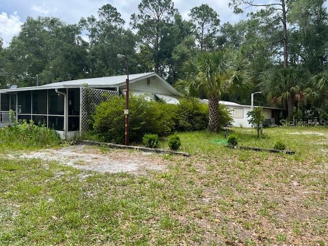 Enjoy small town living private location yet close to shopping Country style home, partially furnished, w/metal roof , large screen porch , attached carport w/storage room , circle Drive off paved road , central A/C & heat, lots of irrigation for flower gardening or vegetable garden. Large work shop w/metal roof . power and wrap around work bench. small green house , nicely treed and private 2 acres in edge of town. All fairly close to suwannee river and springs and just minutes from great Salt Water Fishing in Horseshoe Beach and Steinhatchee.