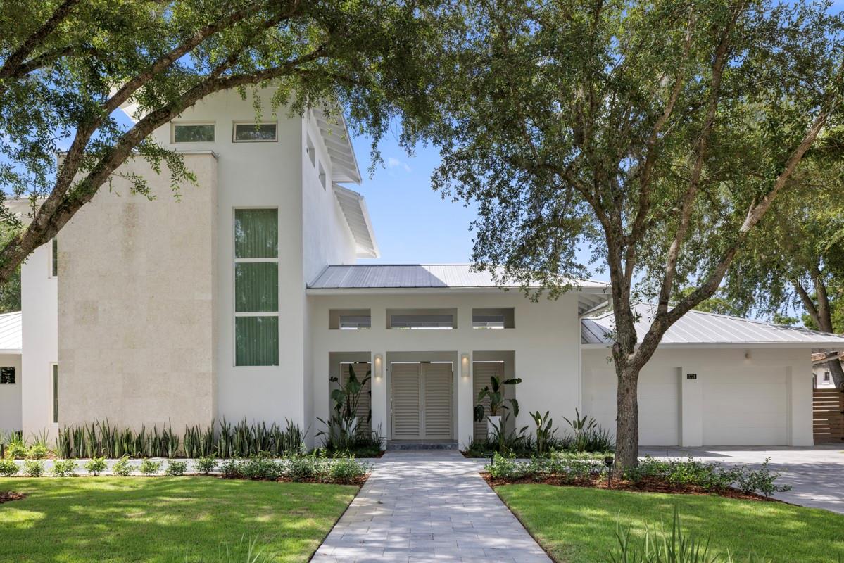 Beautifully renovated and thoughtfully designed, this exceptional residence is nestled in the heart of Winter Park’s sought-after Tree Streets neighborhood. Privately behind entry gates, the home welcomes you with a picturesque front courtyard highlighted by a tranquil water feature, setting the tone for the sophisticated living experience that awaits. Expansive walls of glass and disappearing sliders flood the interiors with natural light while creating a seamless connection between indoor and outdoor living spaces, all while maintaining a remarkable sense of privacy. Designed for both everyday living and effortless entertaining, the open-concept floor plan showcases a spectacular custom entertainment bar featuring a stunning stone countertop, handcrafted cabinetry, an ice maker, a wine tower and a beverage cooler. The great room, dining area and kitchen flow together in one expansive space, framed by pocketing glass doors on both sides that open completely to the front courtyard and the rear lanai, pool and backyard beyond. The chef’s kitchen is a true centerpiece, outfitted with an impressive suite of Wi-Fi-enabled Thermador appliances, including a six-burner gas range with a steam oven and warming drawer and an integrated refrigerator with freezer drawers and additional refrigerated storage drawers. Thoughtfully designed for both functionality and style, the kitchen also features an appliance garage, a dedicated coffee bar, custom cabinetry and a large pass-through window that pockets into the wall, providing convenient service access to the covered lanai. A fully equipped secondary kitchen and butler’s pantry offers abundant storage, a built-in oven, a microwave and an additional refrigerator, making entertaining on any scale effortless. Privately situated on the first floor, the luxurious primary suite serves as a peaceful retreat with direct access to the lanai and outdoor living areas. The spa-inspired primary bath features a sculptural stone soaking tub, an oversized shower with multiple rain shower heads and a secluded outdoor patio complete with an open-air shower. A beautifully customized walk-in closet completes the suite. Additional first-floor amenities include a dedicated office, an elegant powder bath, and a unique dog room. A versatile flex space currently utilized as a spa room with laundry offers endless possibilities as a fitness room, expansive mudroom, storage area or wellness retreat, with direct access to one of the garage bays. The second level features a spacious family room along with two generously sized bedroom suites, each offering walk-in closets and private ensuite baths. One of the home's most remarkable features is the expansive rooftop balcony, complete with a gas fireplace and panoramic views overlooking both the front courtyard and backyard. Whether hosting guests or enjoying a quiet evening sunset, this elevated outdoor living space provides an unforgettable setting. Situated on a sprawling half-acre lot, the property offers exceptional outdoor space with room for future expansion or simply enjoying the privacy and beauty of the backyard, pool and lanai. Ideally located just minutes from vibrant Park Avenue, residents enjoy convenient access to Winter Park’s renowned dining, shopping, parks and cultural amenities, while major roadways provide easy commutes to downtown Orlando, Orlando Executive Airport and Orlando International Airport.