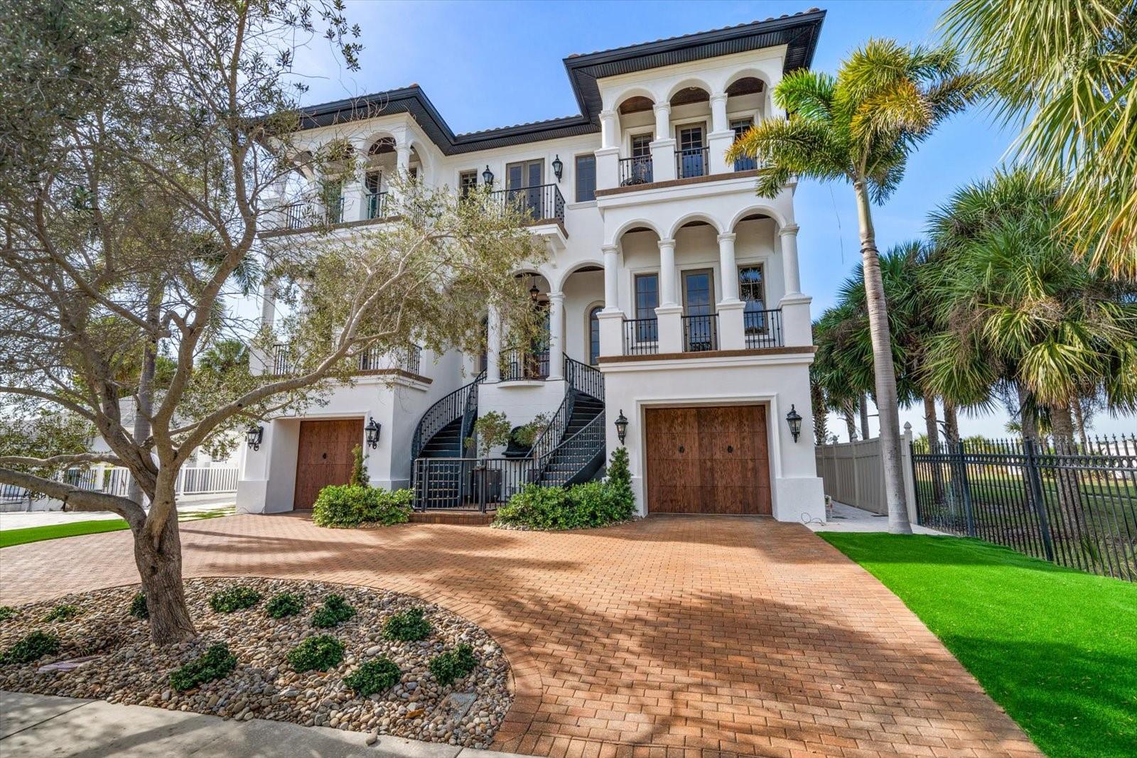 One or more photo(s) has been virtually staged. Welcome to a true Mediterranean masterpiece, an architectural triumph gracing the sugar-white sands of world-famous Clearwater Beach. From the moment you arrive, the home’s commanding curb appeal and refined presence set the tone for a residence designed to satisfy the most discerning buyer. Built in 2009 and perfectly positioned directly on the Gulf of Mexico, this extraordinary estate seamlessly blends timeless elegance with modern coastal luxury, offering breathtaking, unobstructed Gulf views that stretch endlessly from nearly every room. Spanning approximately 5,000 square feet, the home is filled with exquisite architectural detail, sparkling chandeliers, and designer finishes that elevate every space. Rich teak wood floors flow throughout, complemented by marble and natural stone accents that reflect a refined, resort-inspired aesthetic. The interior living spaces are warm yet grand, anchored by a gas fireplace and a stunning designer kitchen crafted for both high performance and visual impact—ideal for intimate gatherings or elegant entertaining. A private elevator provides effortless access to every level, ensuring comfort and convenience throughout the home. Designed for elevated beachfront living, nearly 1,500 square feet of covered outdoor living space invites you to relax, entertain, and dine against the soothing backdrop of rolling waves and spectacular sunsets. A heated pool and spa overlook the Gulf, creating a private resort experience just steps from the sand. The primary suite is a sanctuary unto itself, featuring a sitting area, morning bar, custom couture-worthy walk-in closet, spa-inspired luxury bath, and a private Gulf-front terrace where sunrise coffee and sunset reflections become daily rituals. With five bedrooms, five and a half baths, awe-inspiring views, and an unrivaled beachfront setting, this is more than a home—it is a legacy property, offering privacy, prestige, and panoramic beauty on the Gulf of Mexico. This rare Clearwater Beach estate defines luxury coastal living at its finest.