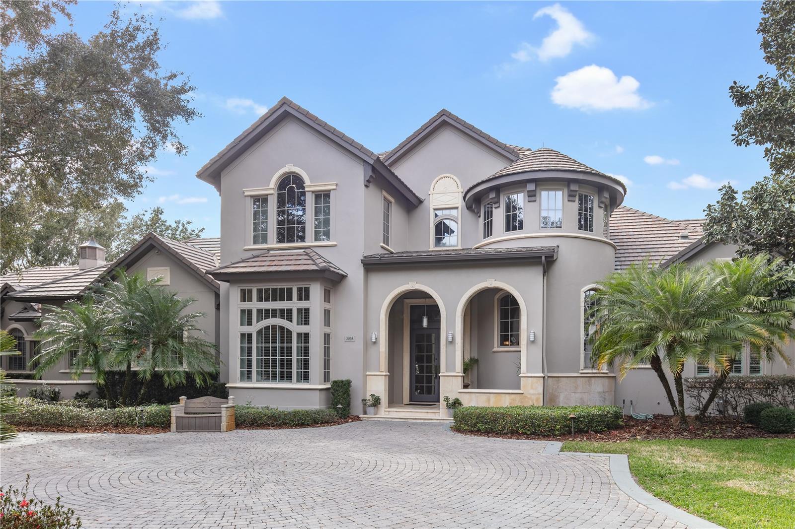 New price for this updated golf front estate with new roof and generator, offers supreme vistas of the 6th Green along the legendary course of Isleworth Golf & Country Club. Spanning over 7,100 square feet, the property features five-bedroom suites in the main house, a semi-detached cabana, expansive outdoor living with sparkling saltwater pool on almost an acre. The circular driveway leads to a freshly painted, grand entrance of this French Country estate. Upon entering, the foyer ceiling soars upwards showcasing a spiral staircase to the second floor. The interior features new paint, flooring and light fixtures to breathe new life to the home. The formal living room floods with natural light from two large windows on either side of the gas fireplace offering lush green vistas of the golf course. The formal dining room, kitchen and breakfast nook are open to the family room which also features French door access to the screened lanai – perfect for entertaining. The renovated kitchen features stainless steel appliances, beautiful white acrylic cabinetry paired with white stone countertops and upper shelving lined with wood detail and warm accent lighting. For entertaining, the first floor, includes butler’s pantry, a separate walk-in pantry, additional food preparation room with secondary refrigerator, laundry room, a full pool bath with shower as well as a separate powder bath off the formal office. The master is situated on the first floor with an office which could be used as a gym. The master bath is equipped with his and her vanities, two water closets, spa tub and a large dual entry shower with multiple shower heads, steam feature and lighting compatible with Sonos app. The second floor offers four bedroom suites, loft with built-in work stations and laundry room. Moving out onto the covered lanai, you have access to the semi-detached guest cabana with full bath inclusive of garden tub and separate shower, walk-in closet, living room and kitchenette. Remote controlled screened expand the covered lanai to the sizeable pool patio and additional covered lanai off the master retreat. The grounds feature an oversized saltwater pool with diving board and heated spa, putting green, basketball half-court and three-car garage with golf cart entry and a workshop. The estate has everything to entertain family and friends while taking full advantage of the Florida lifestyle within the security of a privately gated community.