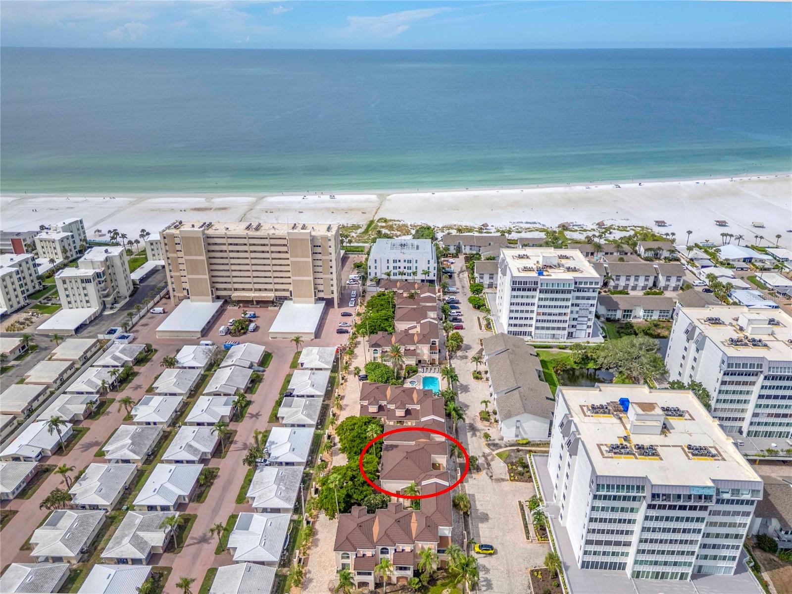 Welcome to coastal elegance and a rare opportunity to own one of only 27 townhomes in the highly sought-after Coquille community, nestled on the picturesque barrier island of Siesta Key, where you are steps to having your feet in the famous soft, white quartz sand that makes Siesta Beach famous.  This spacious and light-filled, furnished 2-bedroom, 2-bathroom residence also includes a Florida room and an enclosed study that can easily function as a third bedroom, offering over 1,760 square feet of refined, maintenance-free living in an intimate, boutique townhome complex. Inside, soaring 17-foot ceilings and clerestory windows flood the open living space with natural light, creating a bright and airy atmosphere perfect for relaxing or entertaining. The kitchen features classic white cabinetry, granite countertops, and stainless steel KitchenAid appliances, all seamlessly integrated with the dining and living areas to offer a cohesive and functional layout. The main-level primary suite includes direct access to the enclosed lanai Florida room and a vestibule with both walk-in and reach-in closets that lead to the primary bathroom, complete with a new stacked washer and dryer for added convenience. Upstairs, a generous 15x13 guest bedroom includes a reach-in closet and is complemented by a hallway with both walk-in and linen closets. The beautifully renovated coastal-style bathroom features a soaking tub and shower combination, while an enclosed loft area currently serves as a third bedroom with a built-in set of drawers and a home office with built-in desk and cabinetry. Additional storage under the stairs, custom built-in drawers along the living room wall, and a private 7x7 storage room downstairs in the garage give you the space and feel of single family home living.  The oversized, tandem garage located directly beneath the residence accommodates 2 to 3 vehicles and includes a designated grill area. The property also features electric hurricane shutters for peace of mind. Recent updates and ongoing community enhancements further elevate the value of this home. A new roof has just been completed, and the community is undergoing a stunning transformation scheduled for completion by year-end.  Improvements include new exterior paint (Sherwin-Williams Alabaster on walls and Sherwin-Williams Underseas on the shutters and front doors), new garage doors (Sherwin-Williams Urbane Bronze), new modern exterior lighting, new fencing, and refreshed landscaping. The current owner has also ordered a new front door to be installed for this unit. Additional system upgrades include a 2019/2024 HVAC system and a 2024 electric tankless water heater. Outside, enjoy the best of the Siesta Key lifestyle with a private boardwalk leading directly to the beach, complete with chairs and chaise lounges for residents. The community also features a recently refinished 36x19 pool and spa area, along with an outdoor shower and restrooms. Coquille is pet-friendly and ideally located just a short walk or drive to the vibrant dining, shopping, and energy of Siesta Village.