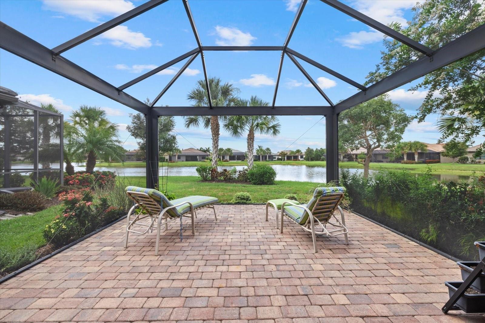 Welcome to Del Webb Lakewood Ranch, the highly rated, premier 55+ community offering an elevated lifestyle! Here is the perfectly located Taft Street model home with a serene water view and situated on a quiet cul-de-sac with close proximity to the amenity center. Lush and colorful landscaping greets you in through an upgraded glass insert entry door to find an inviting open floor plan with plank style porcelain tile floors throughout entire home. The designer kitchen boasts a large center island with seating for 2-3 and the stand out feature is the sink location on expansive countertop at the back overlooking the awesome water views! Also included: designer tile backsplash, stainless steel appliances and spacious pantry. Step directly out the pedestrian door from the kitchen to the highly upgraded and expanded lanai featuring panoramic screens to maximize the views and durable construction to withstand storms and hurricanes. Relax, grill, have a garden, dine and entertain on this fabulous oversized lanai! Your master bedroom suite features a tray ceiling and bath with dual sink vanity, custom mirrors, step in tiled shower, private water closet, linen closet and spacious walk in closet with custom built ins. The convenient split floor plan places the guest bedroom toward the front of the home and right next to the guest bath. There is a cute French door entry den/office at the front of the home that is perfect for home office, craft room or to accommodate additional guests. This home offers a practical and livable floor plan in a great location, is move in ready and a must see! Del Webb offers a vibrant, amenity-rich lifestyle with tennis, pickleball, bocce, fitness center, resort and lap pools, on-site restaurant and bar ($500 annual food & bev. fee) & a full-time Lifestyle Director curating endless activities—all within a golf cart-friendly gated community. Ideally located near Sarasota, Bradenton, Tampa, and award-winning Gulf Coast beaches, this move-in ready home is your perfect opportunity to embrace Florida living at its best—schedule your showing today!