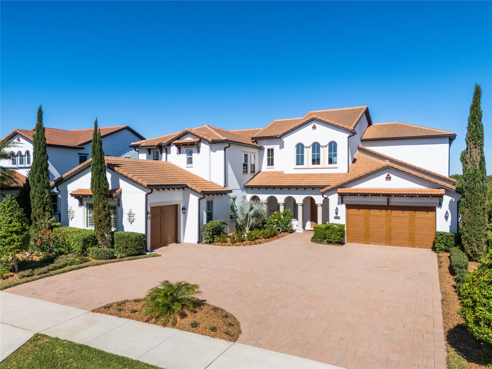 Welcome to this extraordinary luxury home, offering direct lake access on Lake Panther, nestled within the Lakeshore Preserve community in Winter Garden. This 6,000+ sq. ft. residence offers 5 bedrooms, 5.5 bathrooms, an executive office, and a spacious bonus room, all with breathtaking views of Panther Lake. Completely reimagined by the current owner, this home showcases unparalleled craftsmanship and modern elegance. Hundreds of thousands invested in recent updates include engineered hardwood flooring, a completely redesigned kitchen, and a fully reimagined spa-like primary bathroom. Additional updates include another renovated full bathroom and a remodeled downstairs half bath, custom ceiling beams, built-in shelving, accent walls, an electric fireplace, a new built-in grill for the summer kitchen, a redone staircase, laundry room, and butler’s pantry. The modern Mediterranean architecture is enhanced by a circular driveway with dual access points. Step inside to soaring ceilings and immediate, unobstructed lake views. The gourmet kitchen features an oversized quartz island, a large farmhouse sink, and high-end Viking appliances, including an eight-burner natural gas cooktop with dual gas ovens. The kitchen also has an additional built-in electric oven and microwave, new cabinetry, and a Liebherr wine fridge for fine wine storage. The butler’s pantry and walk-in pantry are conveniently located just off the kitchen. The space flows seamlessly into the sitting and family rooms, where expansive lake views and elegant ceiling beams create a stunning focal point. On the west wing of the home, you’ll find an executive office, an updated laundry room, and a large guest suite with its own private garage entrance, making it an ideal in-law suite. The primary suite is also located in this wing, offering private pool access and breathtaking lake views, along with two walk-in closets. The fully remodeled primary bathroom has been transformed into a true spa-like escape, featuring an oversized shower, a soaking garden tub, and high-end finishes. Step outside to experience Florida lakefront living. The outdoor lanai features retractable screens, a heated pool and spa with a waterfall feature, and a summer kitchen with a brand-new built-in grill, creating an ideal space for outdoor cooking and entertaining. The elegant updated open staircase leads you upstairs, where the home continues to impress with a large bedroom featuring an ensuite bathroom and two closets making this an ideal second primary suite. Two additional bedrooms provide comfort and privacy for family and guests. The open loft leads to a screened balcony overlooking Panther Lake. A massive bonus room, currently used as a game room and a TV room, provides endless possibilities. The home features three garage spaces (a two-car and a one-car garage), three AC units, and two tankless Rinnai water heaters. The HOA includes lawn care and access to the amenities, all located on Panther Lake. These include a resort-style zero entry pool, playground, clubhouse, fitness center, firepit, beach volleyball court, a dock on the lake, and a kayak launch. The home is minutes from major highways, Orange County National Golf Center, and Hamlin Town Center, featuring shopping, dining, and entertainment, with Disney World also just minutes away. This luxury home offers breathtaking views, meticulous updates, and the perfect blend of comfort and elegance. Schedule your private tour today.