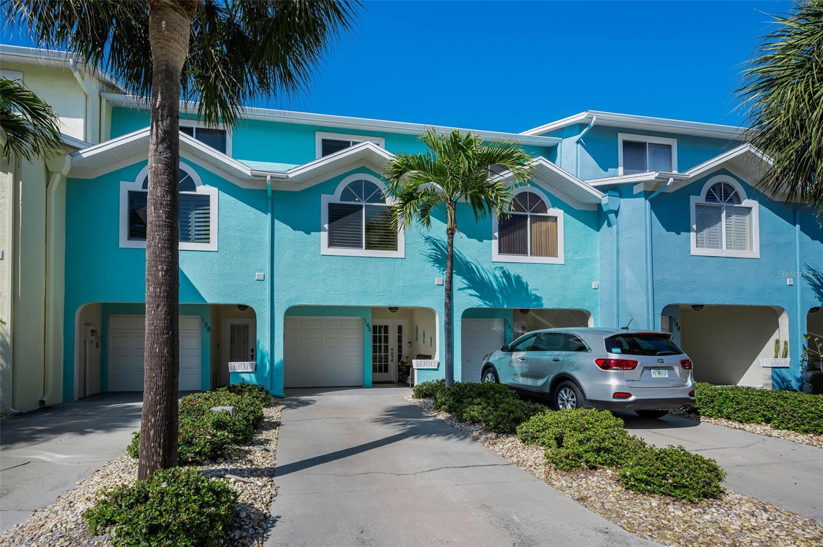 Live the Ultimate Coastal Lifestyle in this fully renovated, Coastal Contemporary 3-bed, 3-bath, 1,656 sq ft Waterfront Townhome with a Deeded Boat slip and expansive Tandem garage with extensive built-ins & storage in the prestigious Sunset Bay Townhome Community of Indian Rocks Beach. Perfectly positioned on the tranquil Intracoastal Waterway, this boater-friendly residence offers unobstructed waterfront views with the Bay and Gulf of Mexico just minutes away. This freshly re-crafted, open-concept home is filled with natural light, soft coastal hues, two (2) waterfront balconies, lower-level paver patio overlooking the water and beautifully renovated interiors. An Atrium-style entry with shaded seating leads to a nautical, beach-chic Foyer and warm wood staircase ascending to the stunning Main level. The Main level / second floor features an expansive Great Room with Island-inspired tones, porcelain plank tile, an elegant marble Fireplace, and a balcony overlooking the Intracoastal. The seaside-modern Kitchen showcases an extended buffet, designer shaker cabinetry, marble countertops, crown molding, oversized social island, tropical stacked glass subway tile, and stainless-steel appliances—perfect for the Chef who loves to stay connected. A main-level Ensuite Bedroom with high ceilings and a beautifully reworked full Bath is ideal for guests. The Upper-level / third floor Primary Suite offers vaulted ceilings, warm coastal colors, a private waterfront balcony, and a shoreline-chic designer bath with a large shower, double-sink vanity, shiplap accents, and large porcelain tile walls. The transformed walk-in closet features a wood organizer and shelving, high ceiling, and skylight. A second upper-level ensuite bedroom with large windows and artfully angled vaulted ceilings and a renovated ensuite bath completes the upper level. Additional value-added features include a lower-level waterfront extended travertine patio in back, outside the garage, newer Impact-rated sliding glass doors and windows, plantation shutters, three (3) Ensuite bedrooms, Porcelain plank tile flooring, Deeded Boat Slip with a new Lift installed in 2021, new Boat Docks, electric and Seawall caps! Sunset Bay is a boutique 30-unit community with a resort-style heated pool and spa, low HOA fees, and pet-friendly policies (large dogs allowed). Located in the heart of Indian Rocks Beach, golf-cart friendly with parks, playgrounds, a boat ramp, beach access, and vibrant local shops and restaurants—this residence is impeccably prepared for immediate enjoyment. Coastal Elegance meets Modern Luxury in this exceptional Contemporary Waterfront retreat that's a true Boater's Delight!
