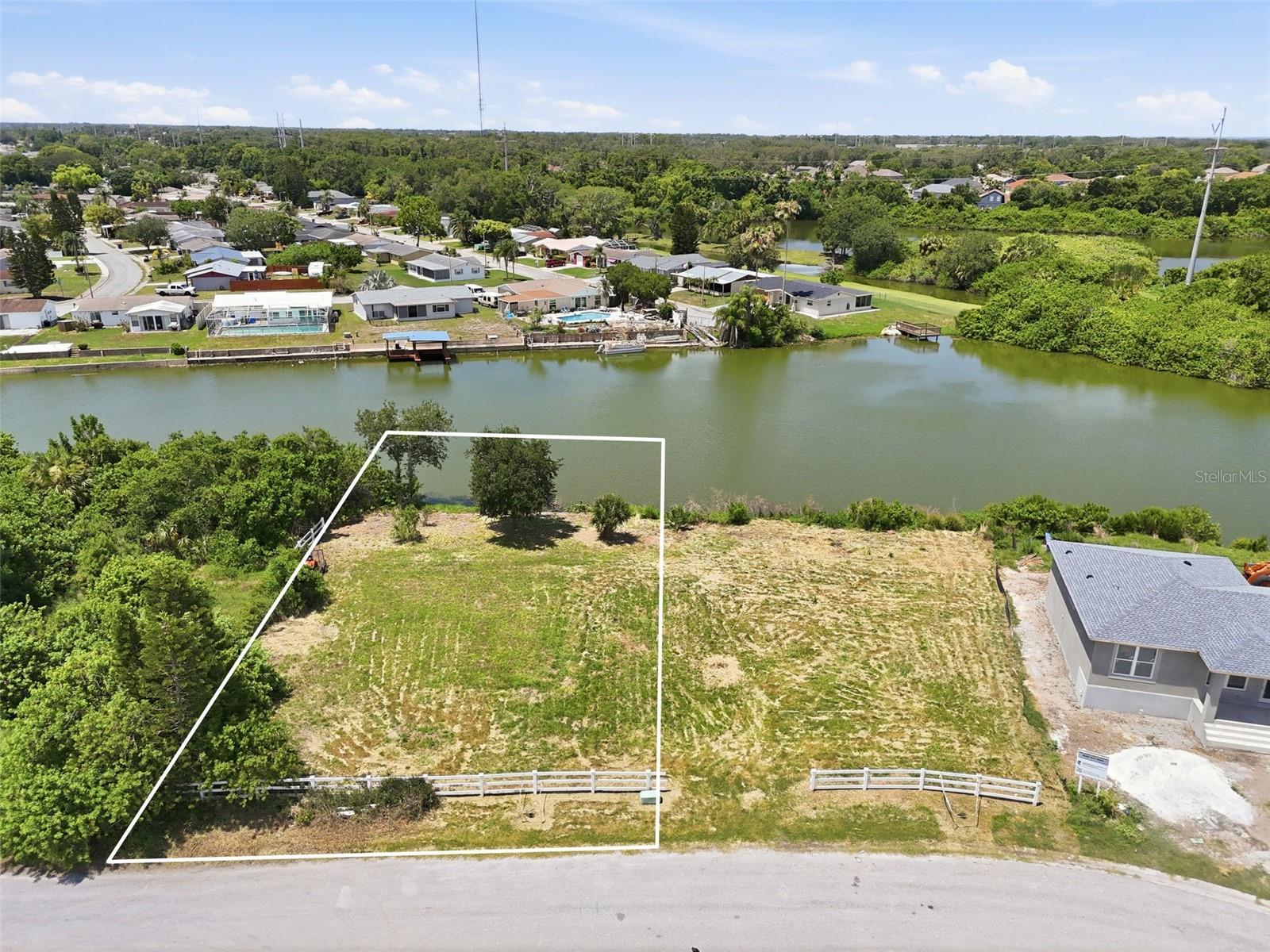 Rare opportunity to build your dream waterfront home on this expansive .27-acre canal-front lot located on a quiet cul-de-sac in Holiday. Offering beautiful canal views and a refreshing breeze, this property provides the ideal canvas for creating your custom Florida retreat. An added bonus - the adjacent lot is also available for purchase, creating the potential for an even larger homesite or investment opportunity. The property line extends into the water, presenting the possibility of adding a private dock and enjoying direct access to the canal. According to the owner, the lot has never flooded during past storms, offering additional peace of mind. Situated on an up-and-coming street, you'll find numerous newly constructed homes nearby, further enhancing the area's appeal. Conveniently located near shopping centers, restaurants, parks, and zoned schools, the property is also just minutes from the J. Ben Harrill Recreation Complex. Historic Tarpon Springs, known for its waterfront dining, sponge docks, local shops, festivals, and year-round activities, is approximately 15 minutes away. Gulf beaches, boating opportunities, and outdoor recreation are all within easy reach. Whether you're looking to build a primary residence, vacation getaway, or investment property, this waterfront lot offers location, potential, and a unique opportunity to enjoy the Florida lifestyle.