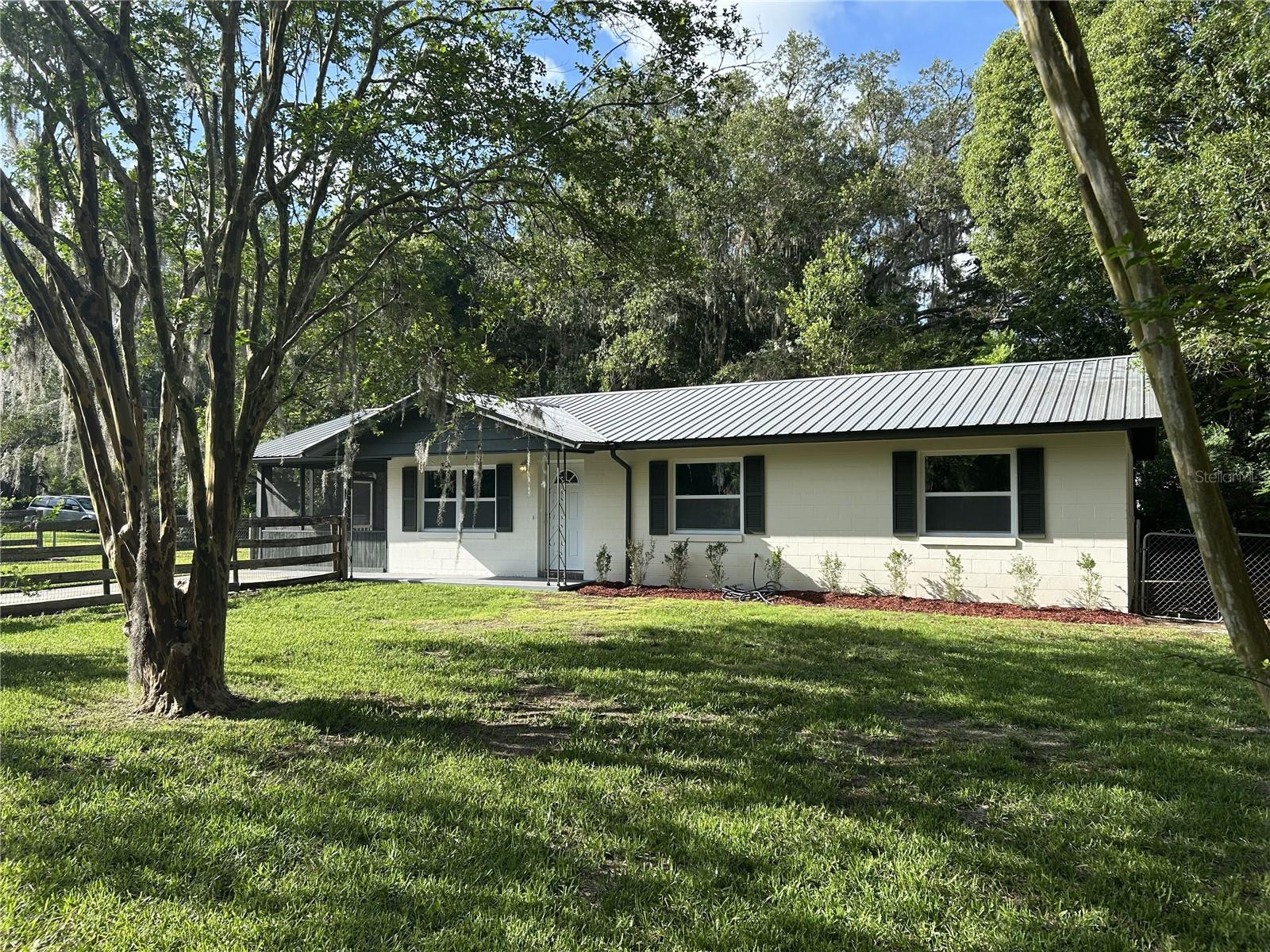 RARE COMBINATION OF PRIVACY, UPDATES, LOCATION & NO FLOOD ZONE! 
This charming 3-bedroom, 1.5-bath home has been thoughtfully updated with vinyl flooring throughout, refreshed kitchen and baths, fresh interior paint, and decorative beadboard accents that add warmth and character. Enjoy peace of mind with a newer metal roof and newer gas HVAC system.
Start your mornings or unwind in the welcoming screened front porch overlooking the spacious front yard and scenic lake across the street. The fenced backyard offers plenty of room to relax, entertain, and create your own outdoor oasis, with space for a pool, garden, workshop, or all your toys.
The city-owned lot next door provides a buffer rarely found in town, offering added privacy and open space. Enjoy the beauty of the lake views without the worry, as this property is located in a No Flood Zone. Conveniently located approximately 30 minutes from both Gainesville and Ocala, this move-in-ready home offers the perfect blend of small-town charm and everyday convenience.
Don’t miss this opportunity to enjoy peaceful living, added privacy, room to grow, and a prime location with easy access to both Gainesville and Ocala!
