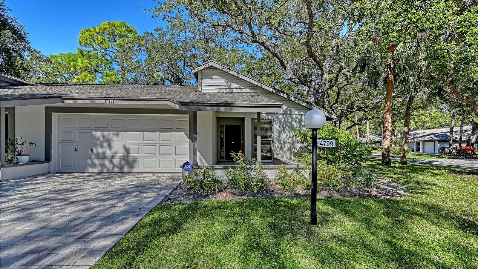 Virtually Staged. You will love Oak Forest with all the mature trees and grassy landscaped areas and its LOCATION!  Just minutes to Siesta Key Beaches, Downtown shopping, restaurants, social events and theater.  This community is impeccably maintained and modernized.  Conveniently located directly across from the community pool and tennis courts, the entire interior of this end unit was just painted and all of the popcorn has been removed.  The guest bathroom totally remodeled with a walk-in shower.  New never been used stainless steel appliances: refrigerator, stove and dishwasher are included.  Tile flooring throughout the villa with vinyl flooring for easy maintenance in the guest bedroom.  Primary bedroom has brand new carpet and offers two walk-in custom designed closets for maximum efficiency.  Primary bathroom designed with dual sinks and a walk-in shower with glass doors. The Primary Bedroom, Living Room and Kitchen have sliding glass doors to access the extended private lanai.  This community is not an age restricted community, is pet friendly and offers tennis, pickleball, heated pool and clubhouse.  Whether you are a snow bird or a full-time resident this property checks desired boxes for your new home.   Association replaced the roofs about two years ago, painted all exteriors and installed paver driveways.  AC was replaced in 2025. The Association remains diligent regarding their finances and are fully reserved. No CDD fees!
