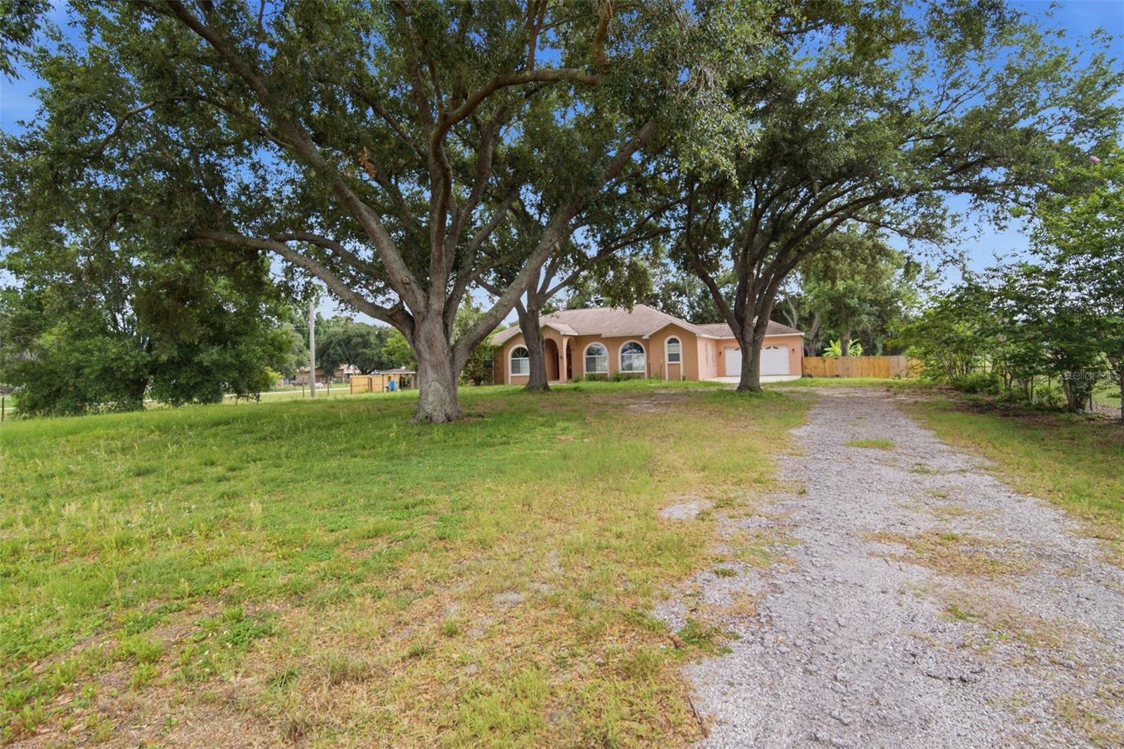 Nestled on 1.64 peaceful acres,this beautifully updated home offers the perfect blend of comfort, space, and privacy.  Featuringhigh ceilings, a spacious living room with a view and ample space for formal and informal dining.  There are four large bedrooms,2.5 baths and a large office. This move-in-ready property showcases tile flooring throughout, a cozy firplace, and fresh intreior and exterior paint.  The spacious kitchen includes newer appliances, while major updates provide peace of mind.  Updates include a 2020 roof, heat pumpreplace 2025 water filtration system, and new water heaters.  Enjoy outdoor living on the large deck overlooking the serene property.  Additional features inculde a security system and plenty of room to relax and entertain both inside and out.  This is country-style living with updates already done for you!