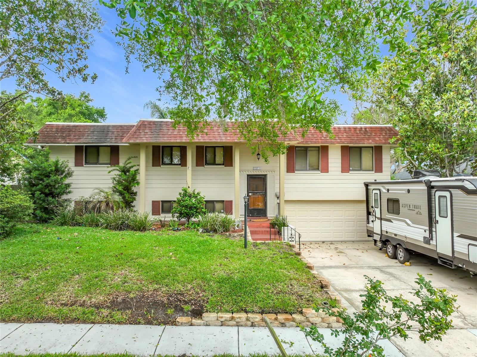 This AMAZING!, spacious 5-bedroom, 3-bath split-level home is located in a fantastic neighborhood and is packed with standout features. Upstairs, you’ll find beautiful engineered hardwood flooring throughout the main living areas, with carpet in the bedrooms and tile in the baths. A stunning screened-in porch overlooks the backyard and pool, offering a perfect spot to relax or entertain.

The bright and airy formal living room provides plenty of space, while the  dining room includes sliding doors that lead out to the porch. The large eat-in kitchen offers ample cabinet storage and even features a convenient pass-through window to the porch/outside bar—ideal for hosting.

The upper level includes three bedrooms two bathrooms.   Just a few steps down, the lower level opens to a massive family room with tile floors  set to entertain family and friends with two additional bedrooms with carpet and a full bath. Tile flooring runs throughout this level.

Additional highlights include  outdoor spa , updated windows, a re-piped plumbing system, updated Electrical, and a well-maintained interior full of character. The home comes with paid in full solar panels and a Terminix termite bond and Well Maintained  sprinkler system on well.  Washer/Dryer are located in the garage.  The garage include cabinets for additional storage.  The yard features mature Citrus trees and Magnolia trees adding to the home’s charm.

With its flexible layout, inviting screened porch, and beautiful salt water pool area, this home truly has it all.