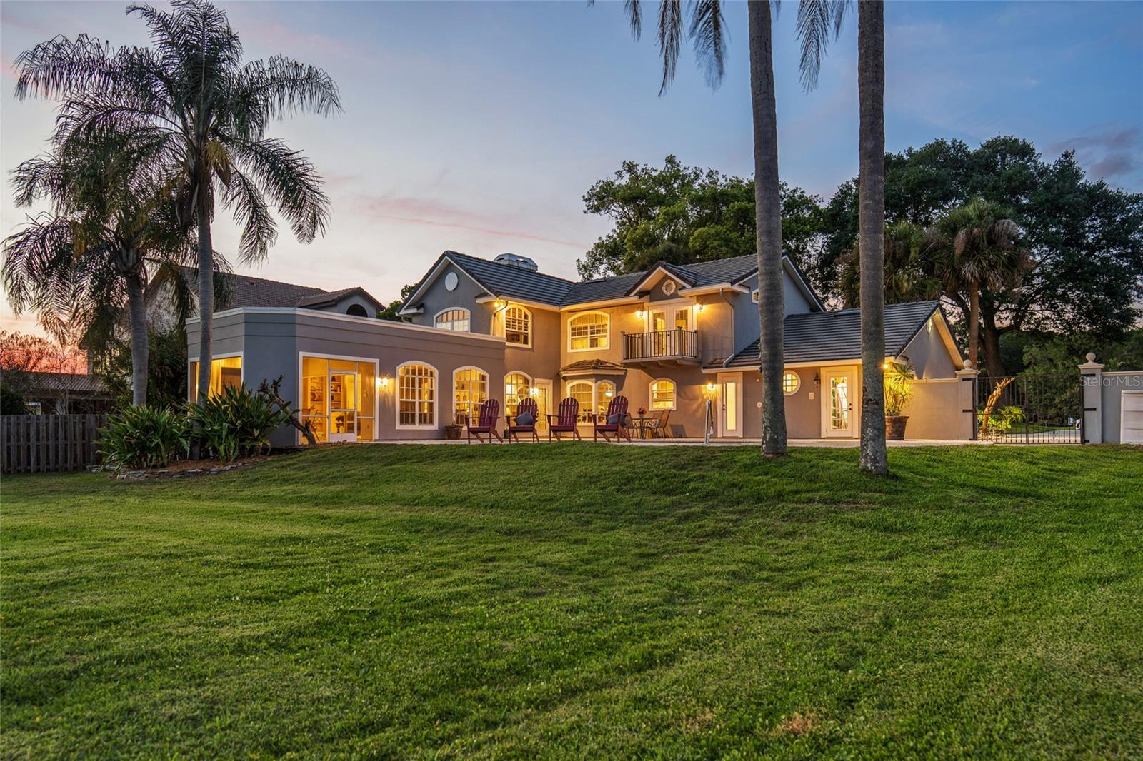 Lakefront living on the Butler Chain of Lakes in the heart of Windermere. This rare offering on Lake Down presents 100 feet of direct frontage, expansive water views and a private setting on a quiet cul-de-sac with no HOA. Set across 1.35 acres, this two-story pool home captures the essence of Windermere’s enduring lakefront lifestyle, where space, privacy, and natural beauty come together in a setting that feels refined and relaxed. From sunrise to sunset, the backdrop is nothing short of extraordinary. Sweeping views stretch across Lake Down, where calm morning waters give way to vibrant evening skies, and a nightly Disney fireworks view adds a subtle sense of wonder to the horizon. The property is thoughtfully oriented to take full advantage of its surroundings, featuring a private beach area, a two-story dock and direct access to the Butler Chain, one of Central Florida’s sought-after and interconnected lake systems, known for its recreational appeal and timeless value. Inside, the home offers a layout designed for everyday living and effortless entertaining. Spacious living and family rooms are complemented by an open kitchen appointed with granite countertops and stainless steel appliances, creating a central gathering space that flows naturally to the outdoors. A dedicated office or den provides flexibility for work or quiet retreat, while an upstairs loft captures elevated, panoramic views of Lake Down, an ideal setting for a secondary lounge, media space or creative studio. The outdoor experience is equally compelling. A resort-style pool anchors the backyard, accompanied by a screened porch and expansive lawn that extends toward the water’s edge. The setting invites relaxed afternoons and large-scale gatherings, with ample room to further enhance or personalize the landscape. A greenhouse and additional storage add charm and functionality, supporting a variety of lifestyle needs. A second-story balcony offers yet another vantage point, where elevated lake views and evening fireworks create a memorable daily backdrop. Whether enjoying a quiet morning coffee or winding down at sunset, this space reinforces the home’s seamless connection to its environment. Positioned in a peaceful and private location, yet just moments from renowned restaurants, shopping and everyday conveniences, the property offers a rare balance of seclusion and accessibility. Its location on one of the desirable stretches of Lake Down further underscores its long-term appeal. This is a compelling opportunity to enjoy the home as it exists today or to reimagine the site as an exceptional custom waterfront estate. In a setting defined by natural beauty, established luxury and enduring demand, properties of this caliber and positioning are increasingly rare.